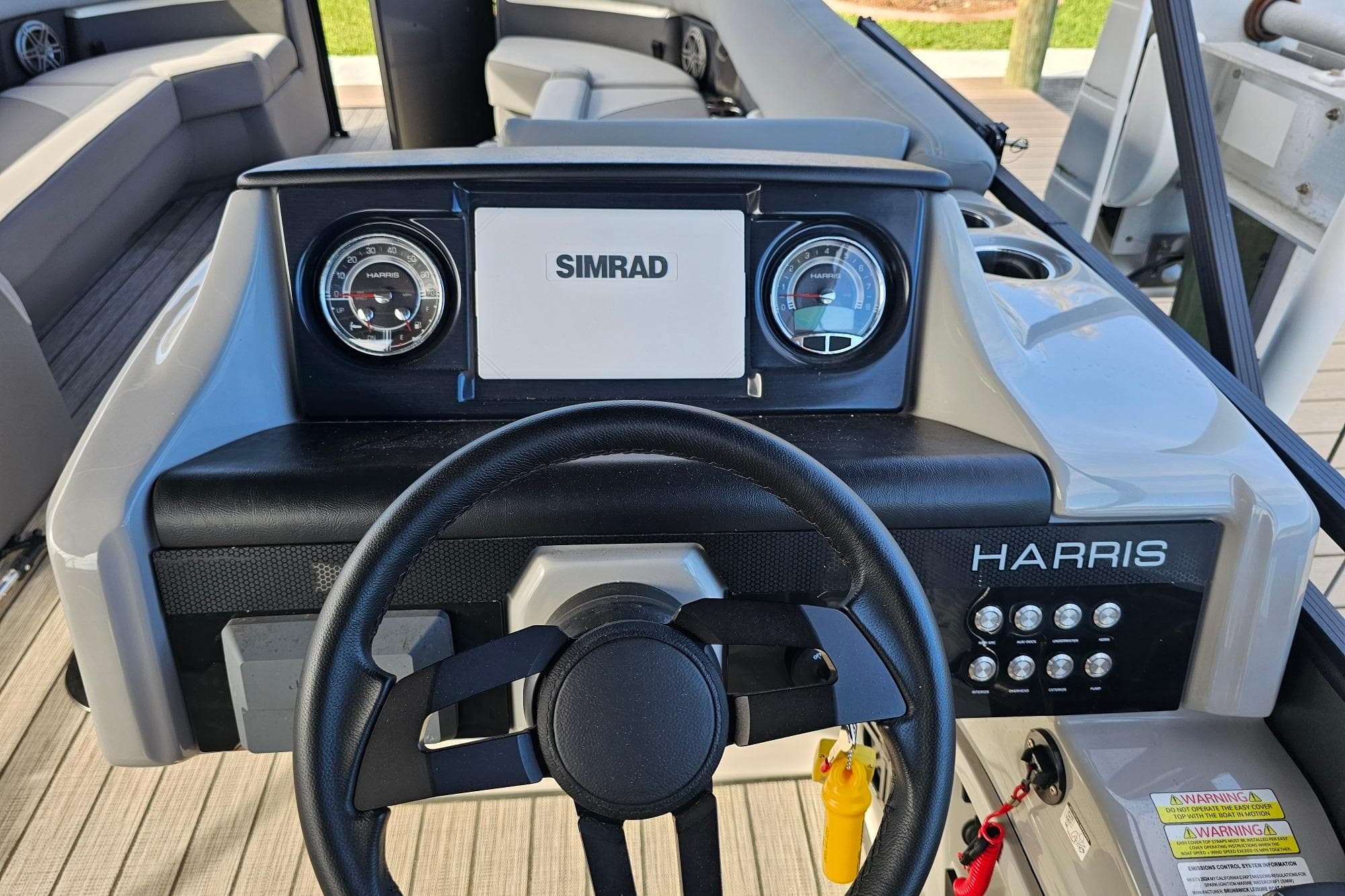 2024 Harris boat dashboard with Simrad display and steering wheel.