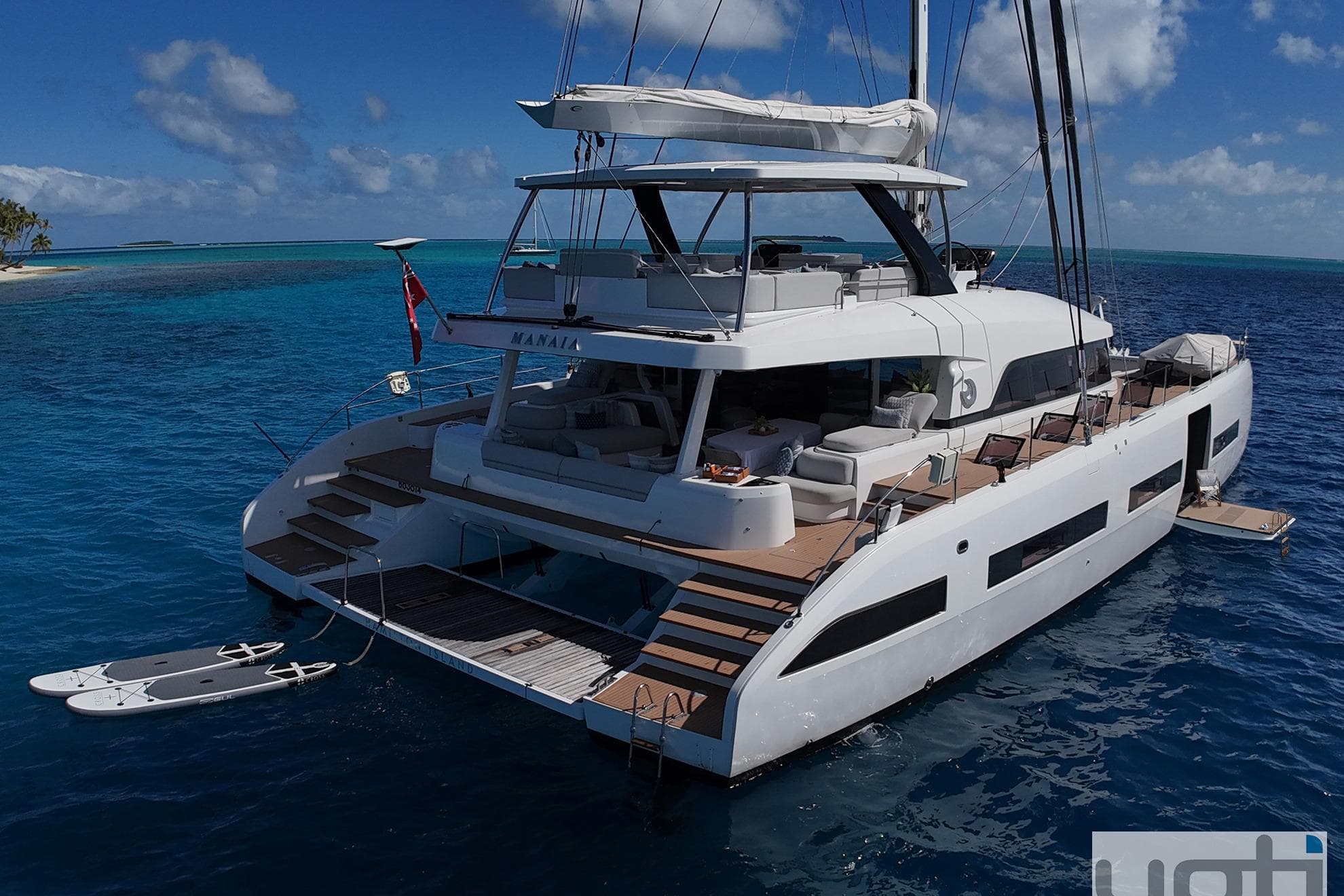 Luxurious 2023 Lagoon SEVENTY 7 yacht anchored in clear blue tropical waters.