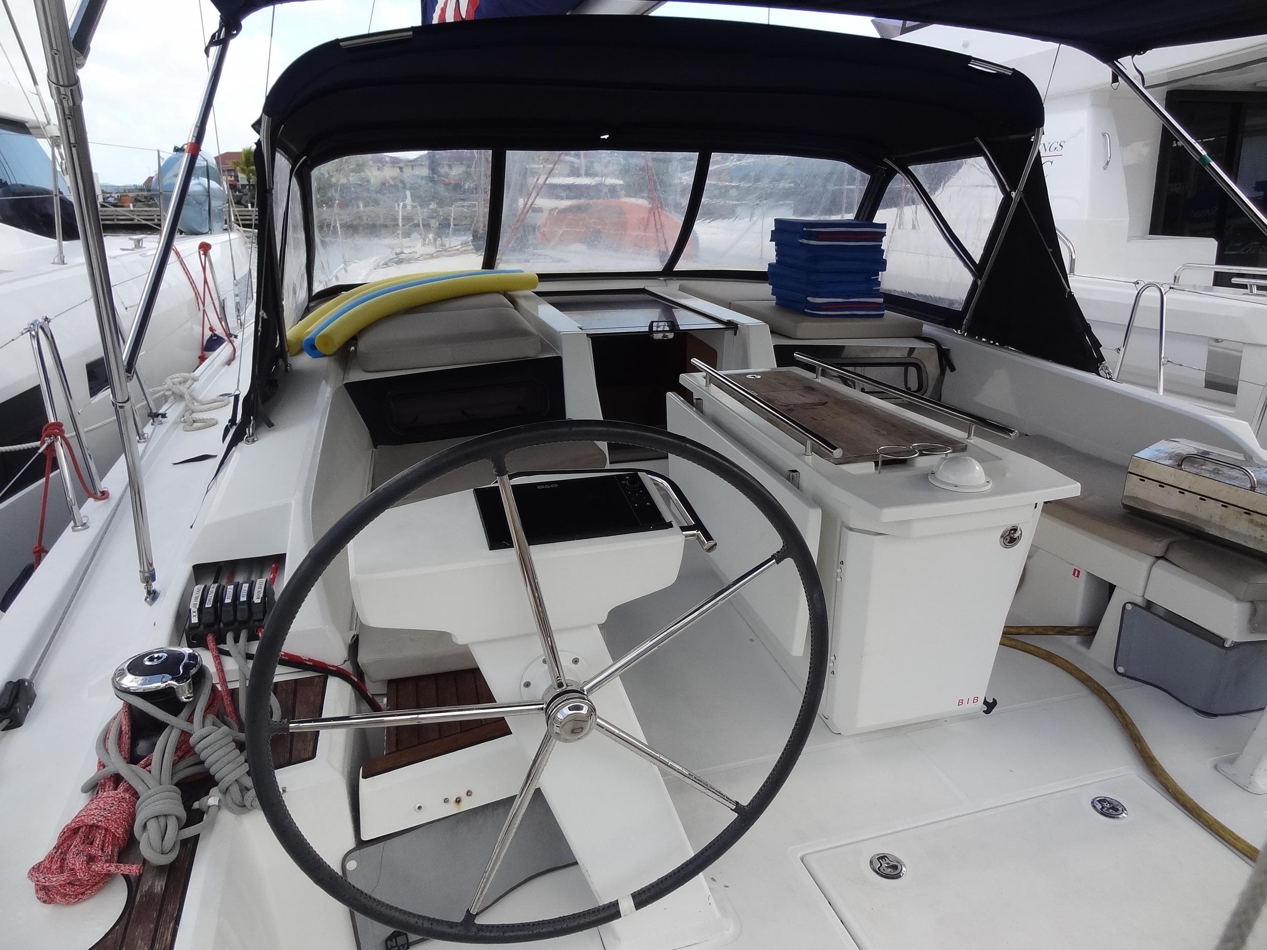 Cockpit of 2020 Beneteau Oceanis 46.1 sailboat with steering wheel and covered seating area.