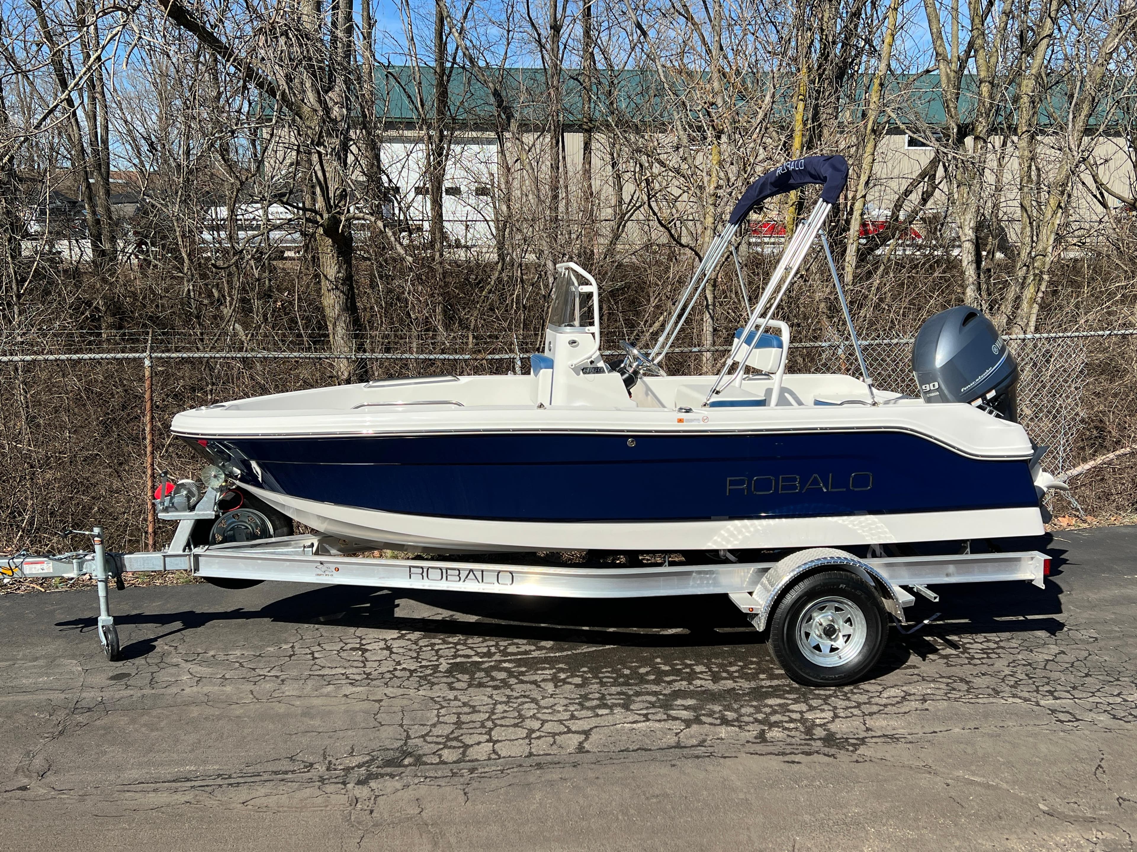 2025 Robalo R160 Center Console boat on trailer, parked outdoors.