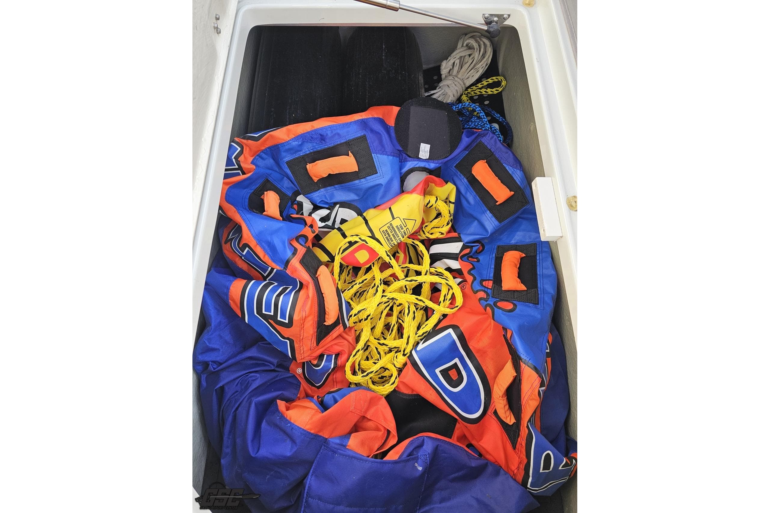 Storage compartment of 2019 Crownline 275 SS boat with colorful inflatable and ropes.