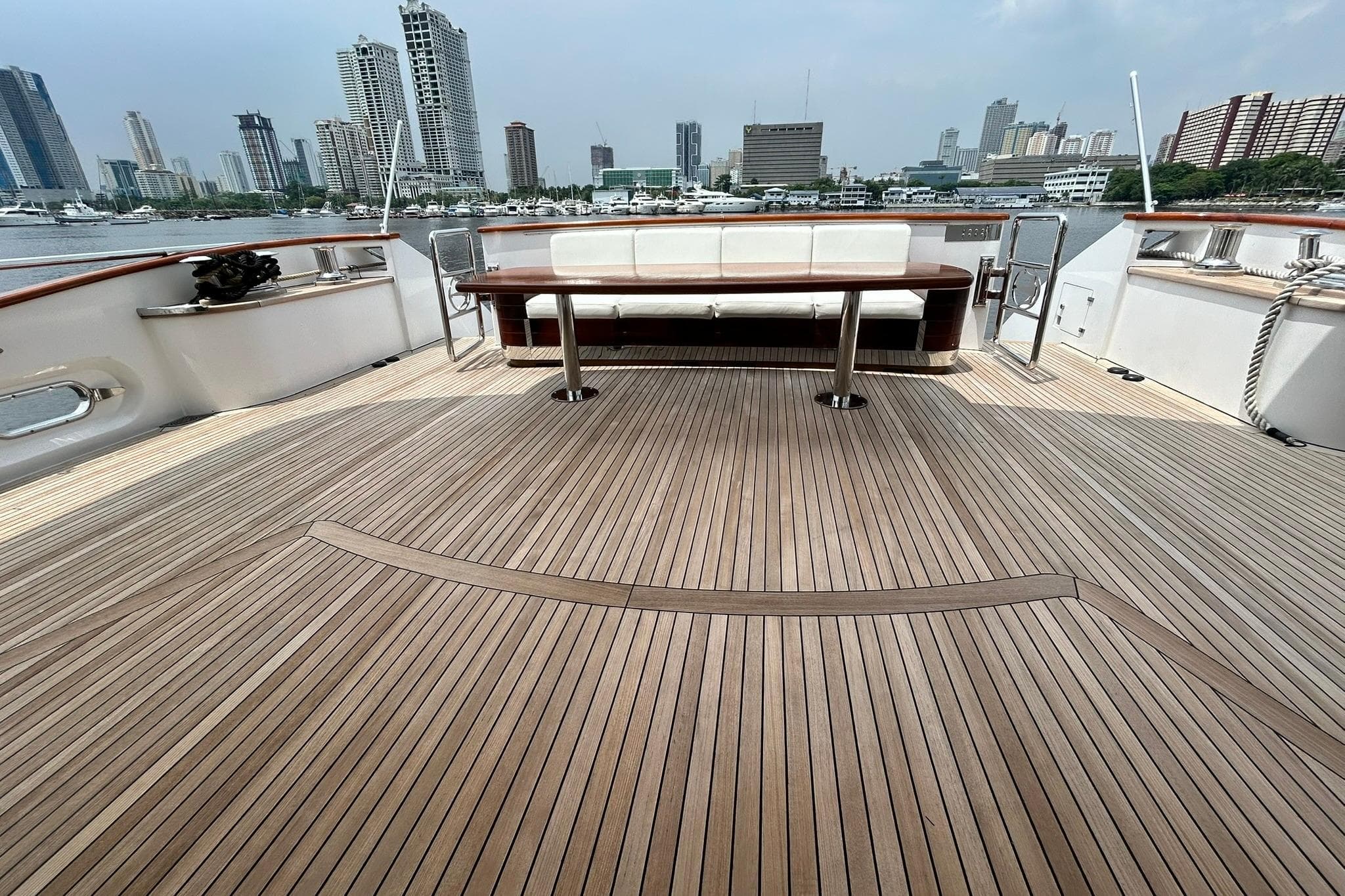 Spacious deck of 2010 Versilcraft Euroyacht Planet 125S Hardtop with city skyline view.