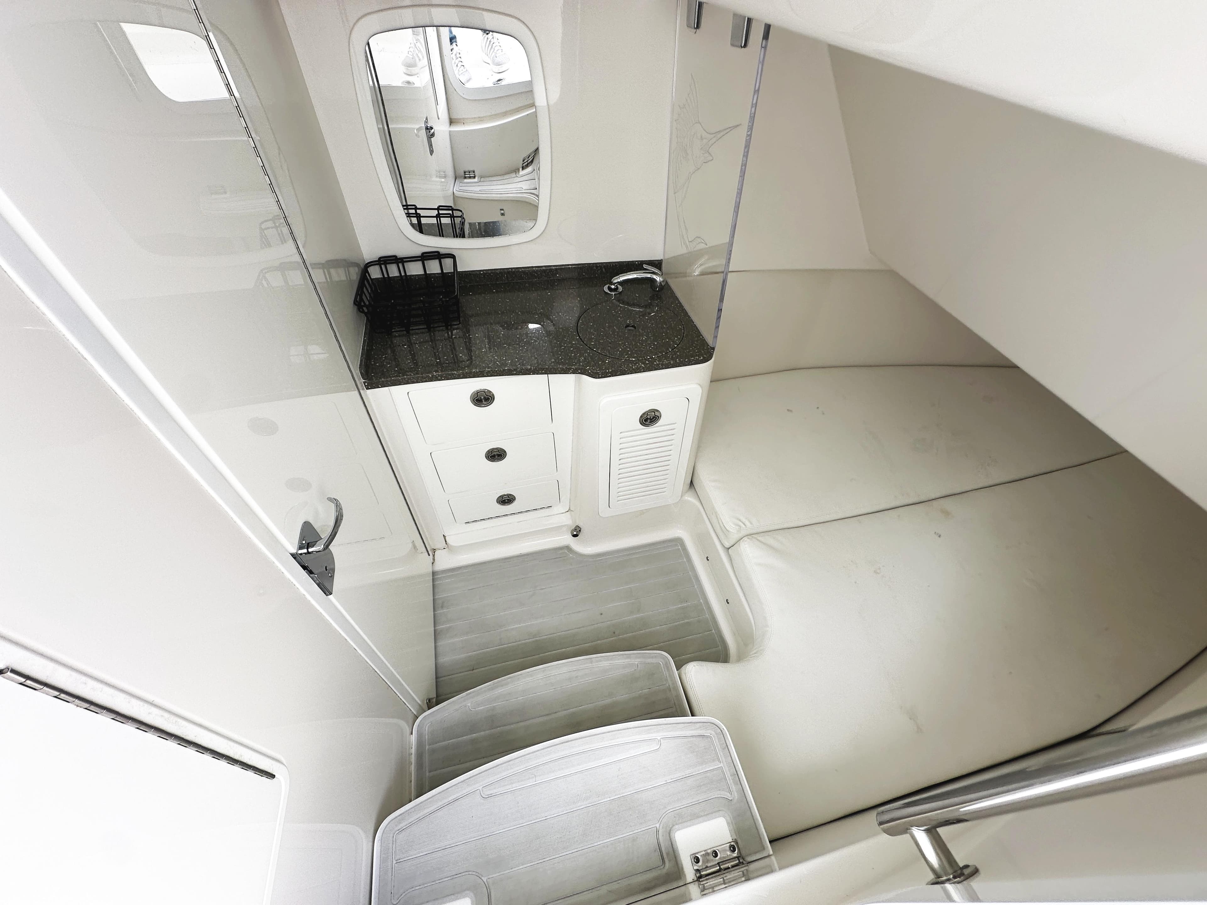 Interior cabin of 2018 HCB 39 Speciale boat, featuring a compact kitchenette and seating area.