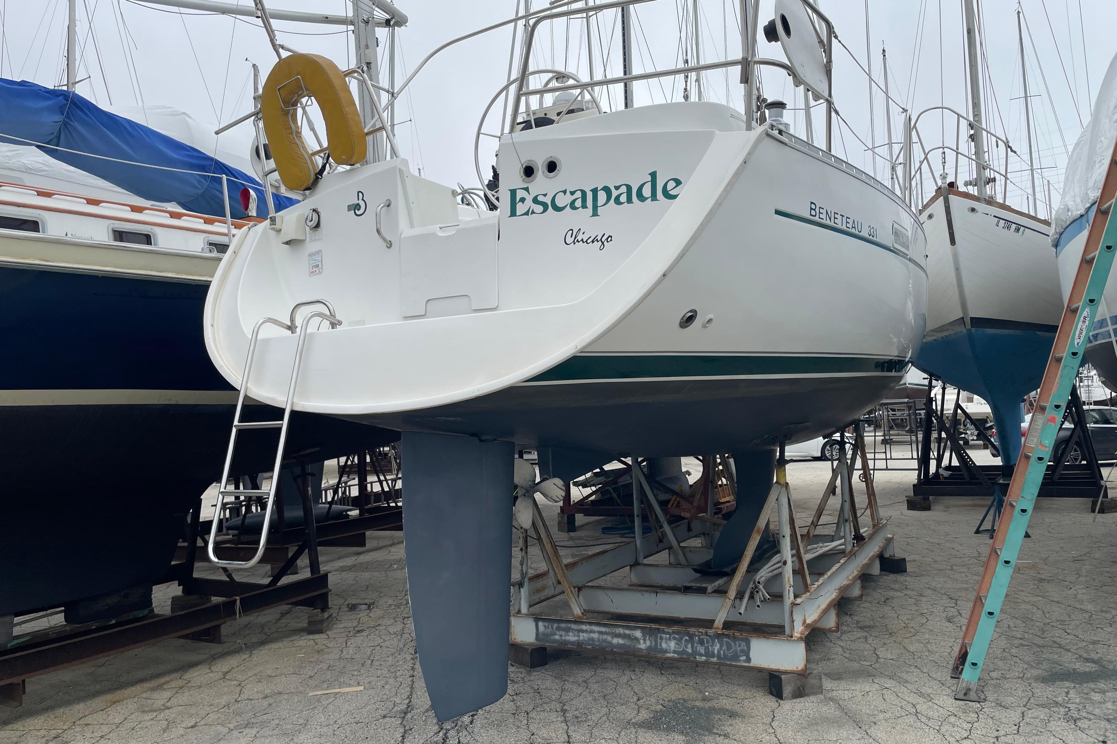 2002 Beneteau 331 sailboat on dry dock, named "Escapade," with visible ladder and keel.