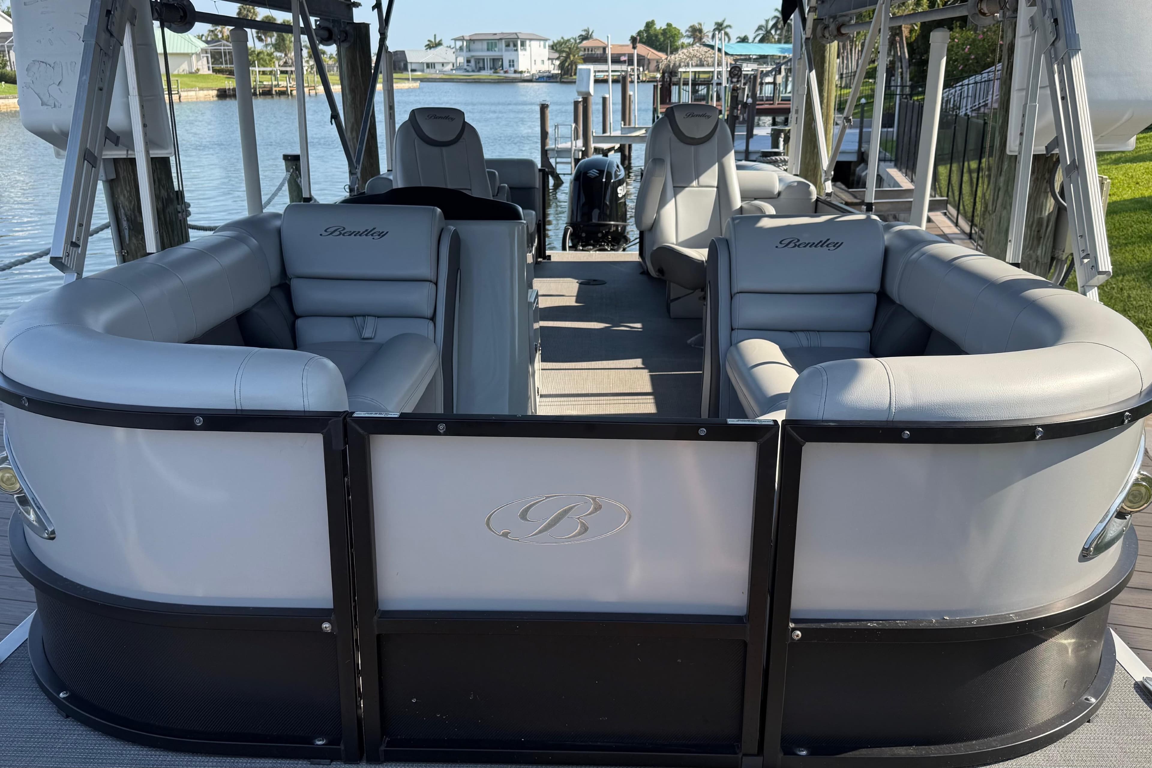2021 Bentley Pontoons 220/223 Elite Admiral with luxurious seating on a serene waterfront.