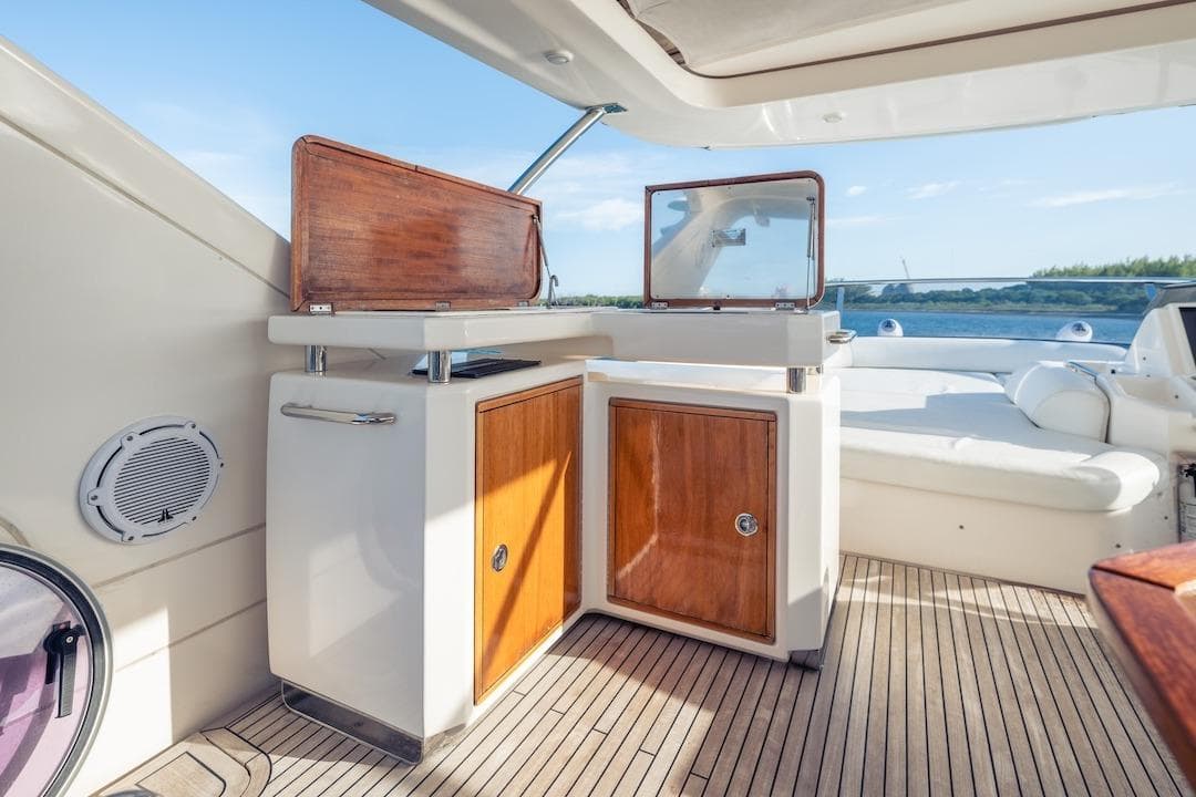 Luxurious 2012 Azimut Evolution yacht interior with wooden cabinetry and scenic water view.