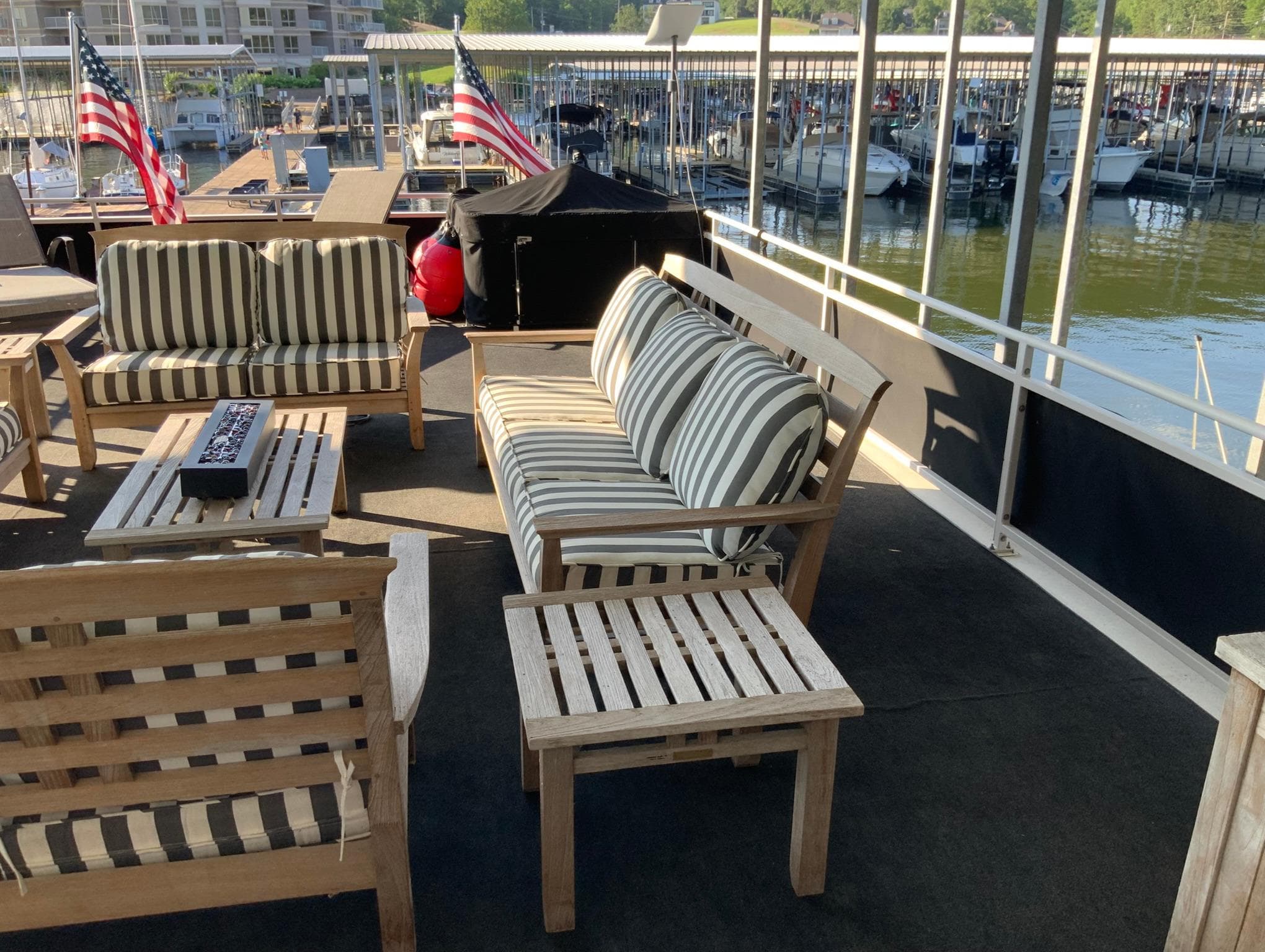 Outdoor seating area on 2007 Skipperliner 640 houseboat with striped cushions and lake view.