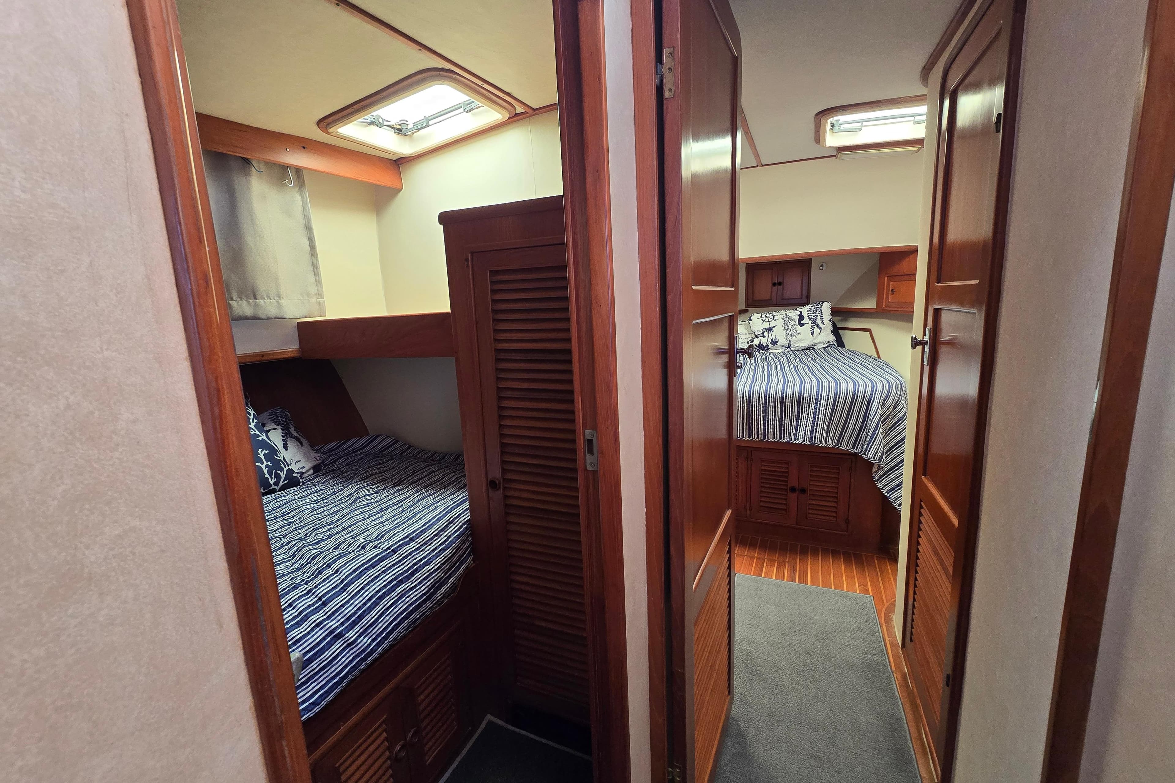 Interior of 1989 Offshore Yachts 48 Sedan, featuring cozy twin cabins with wooden finishes.