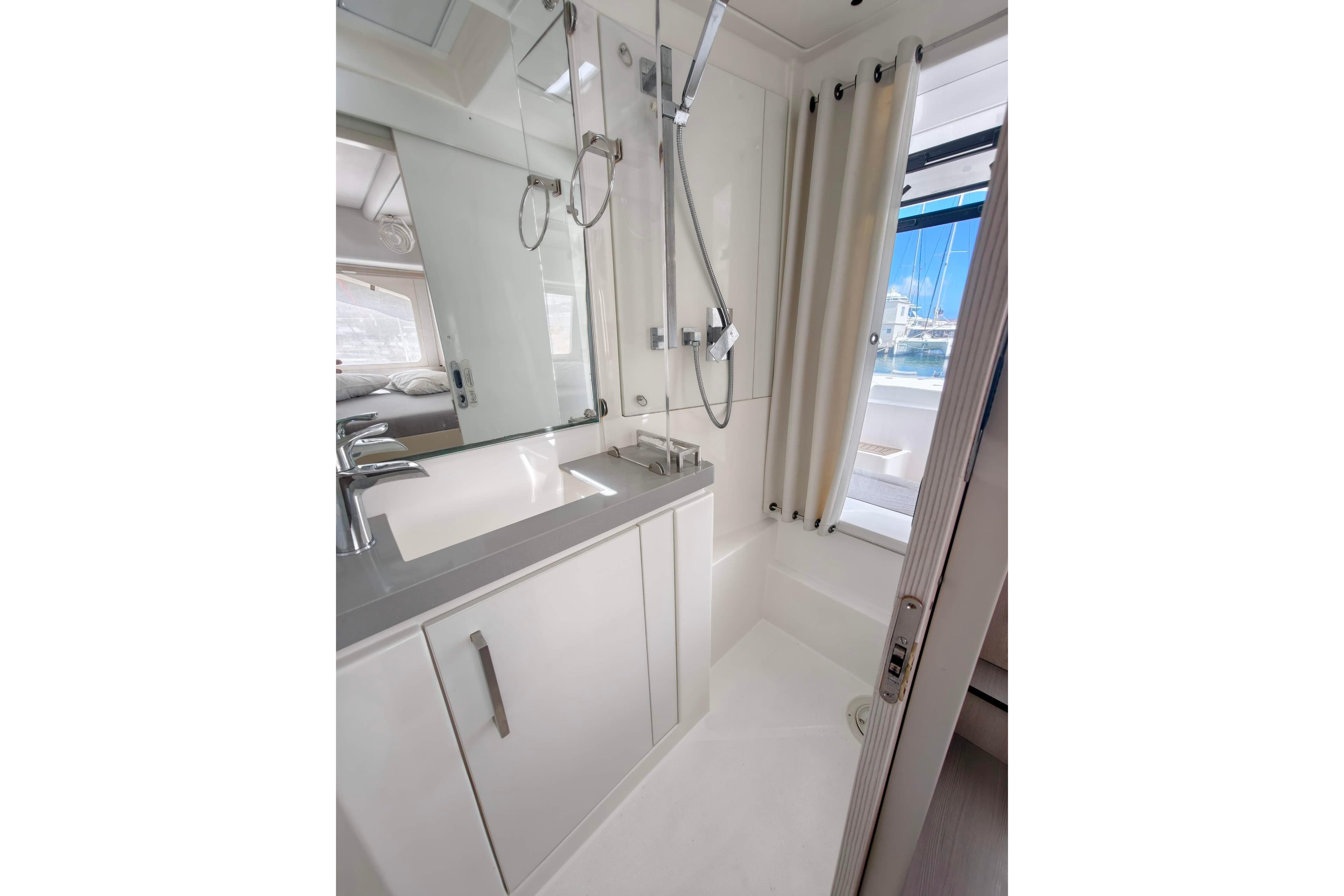 Modern yacht bathroom with sleek fixtures, shower, and window view. Leopard 58, 2020 model.