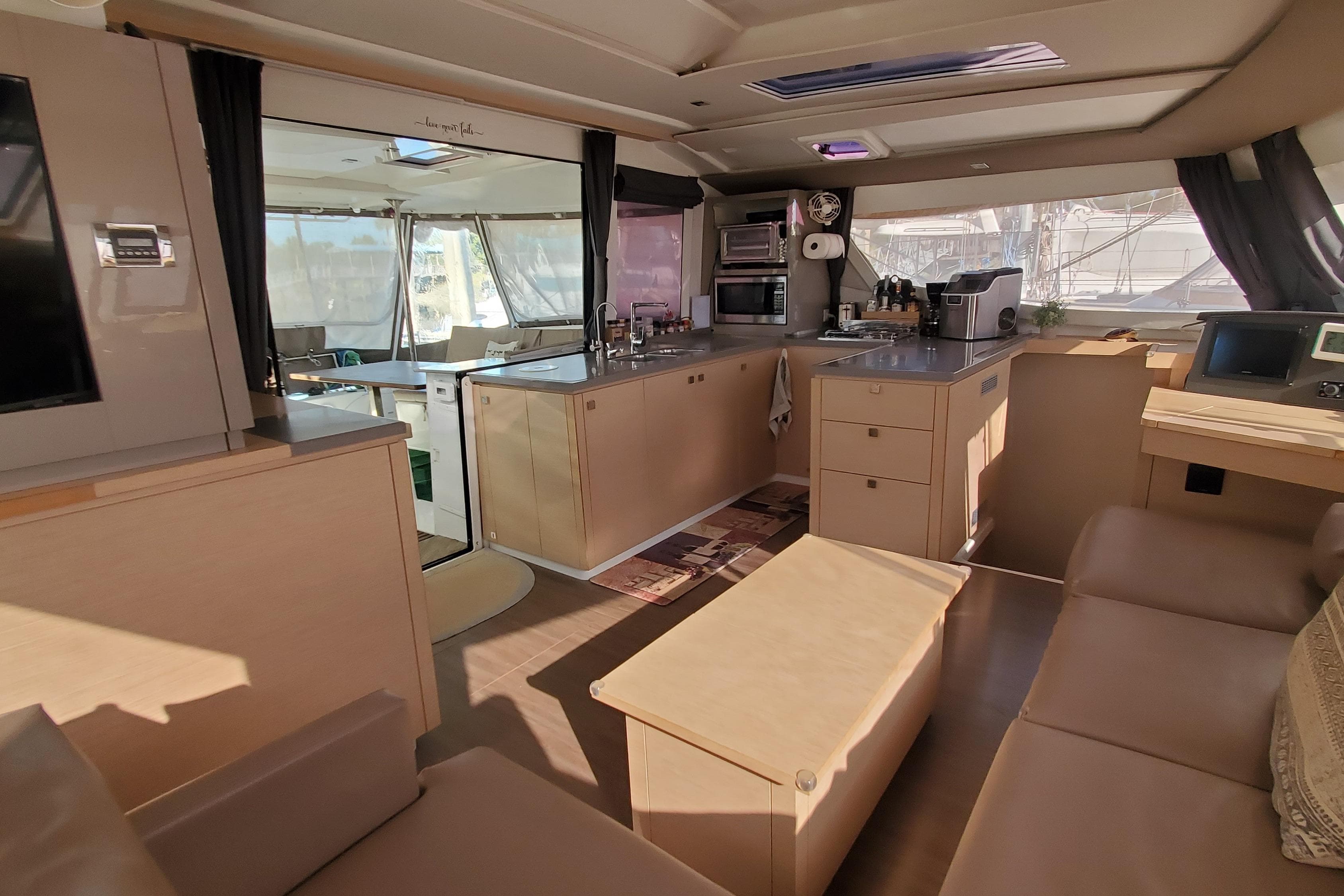 Luxurious interior of 2018 Fountaine Pajot Helia 44 Evolution catamaran, featuring modern kitchen and seating.