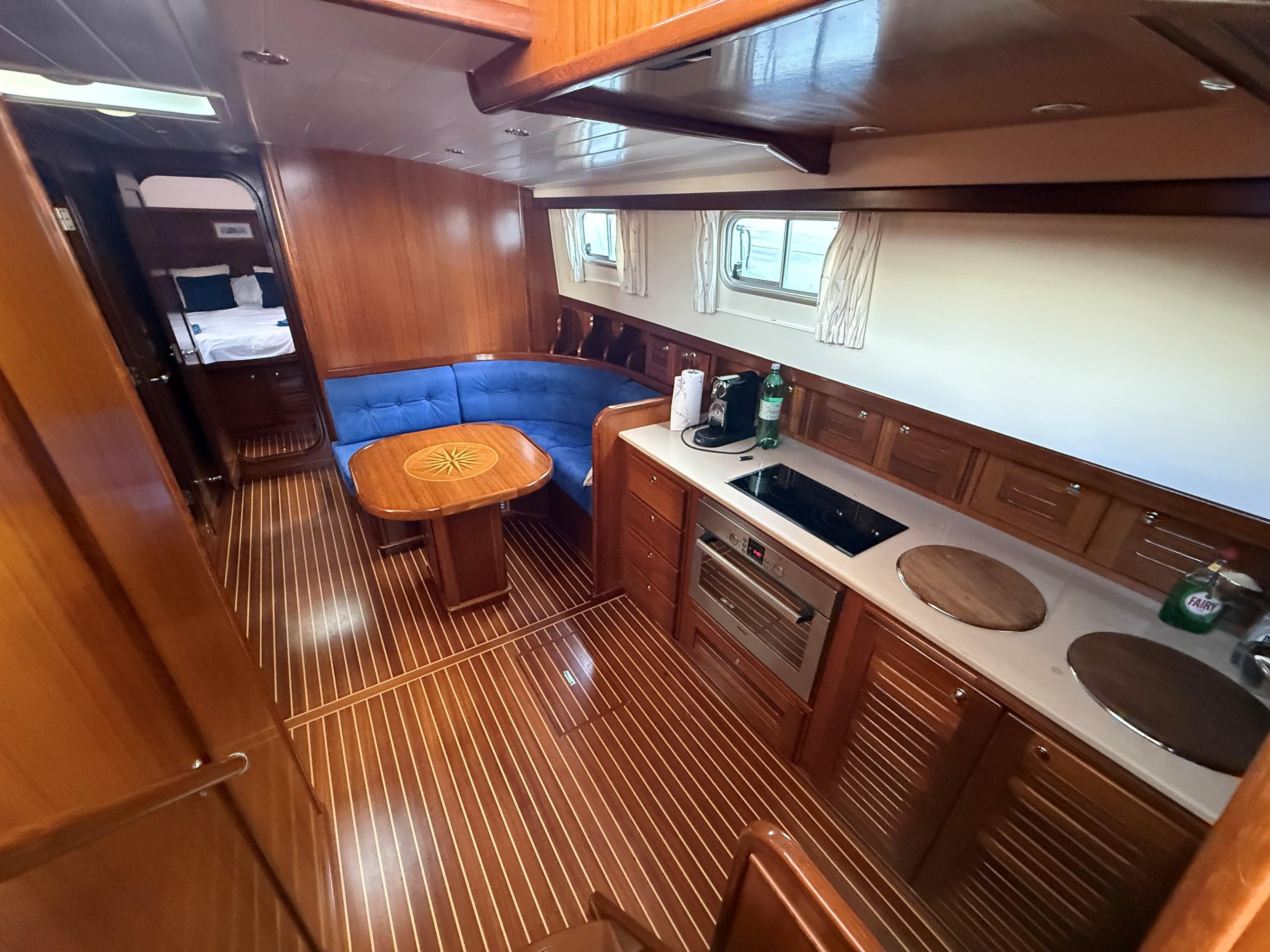 Luxurious 2006 Menorquin 160 Fly yacht interior with wood finish, kitchen, and seating area.