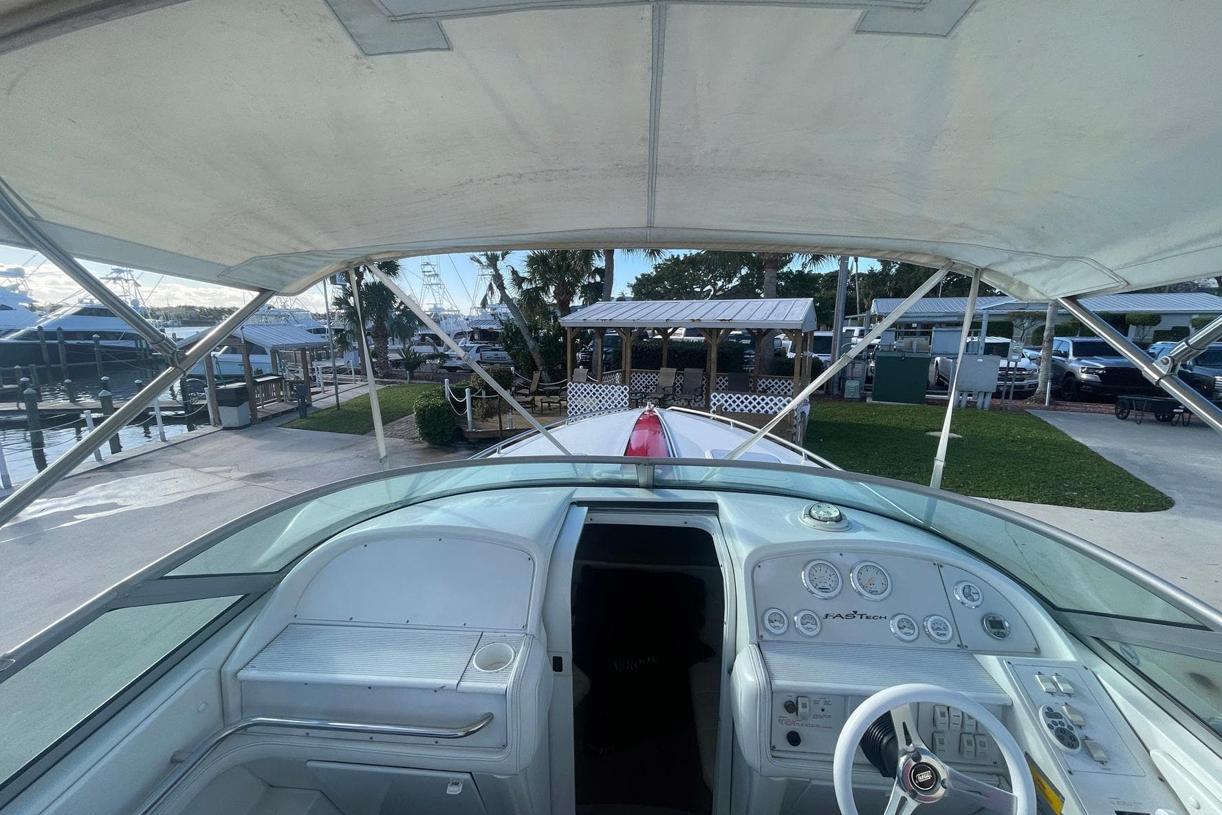 2001 Formula 271 FASTech boat cockpit with steering wheel and dashboard, docked at marina.