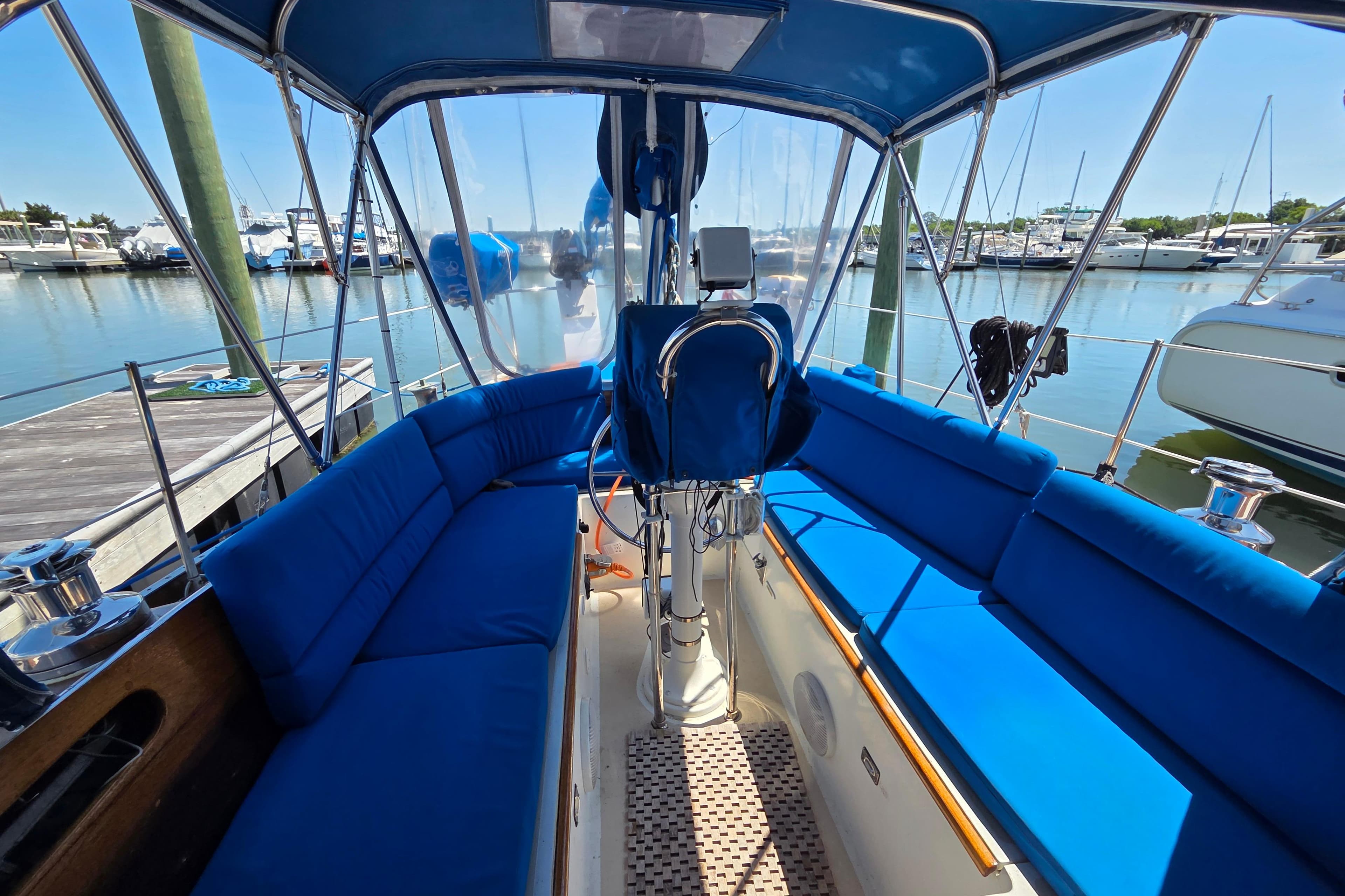 Interior view of a 1961 Hinckley Bermuda 40 sailboat with blue seating at a marina.