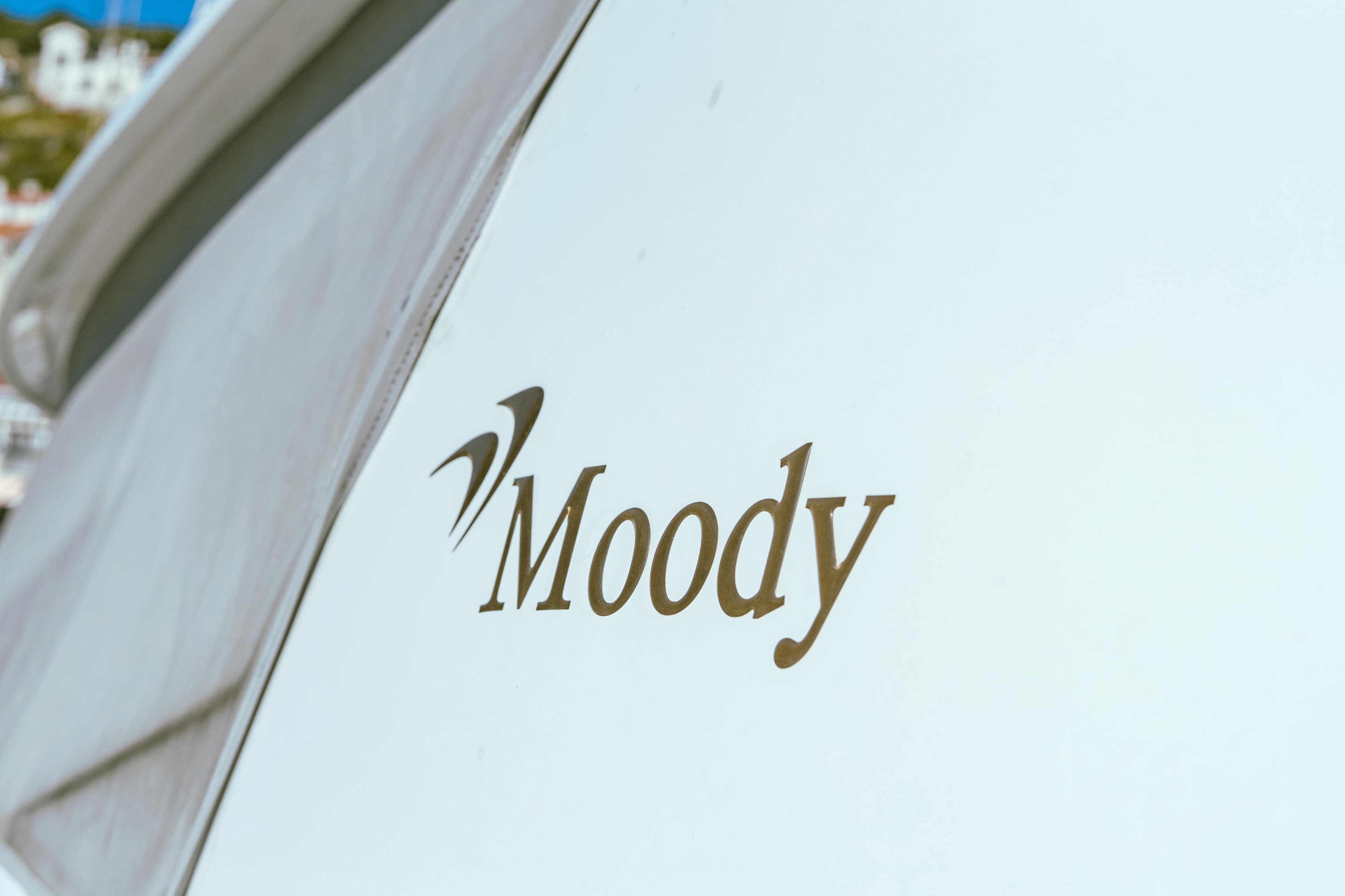 Moody 54 DS 2016 yacht logo on white hull, close-up view.