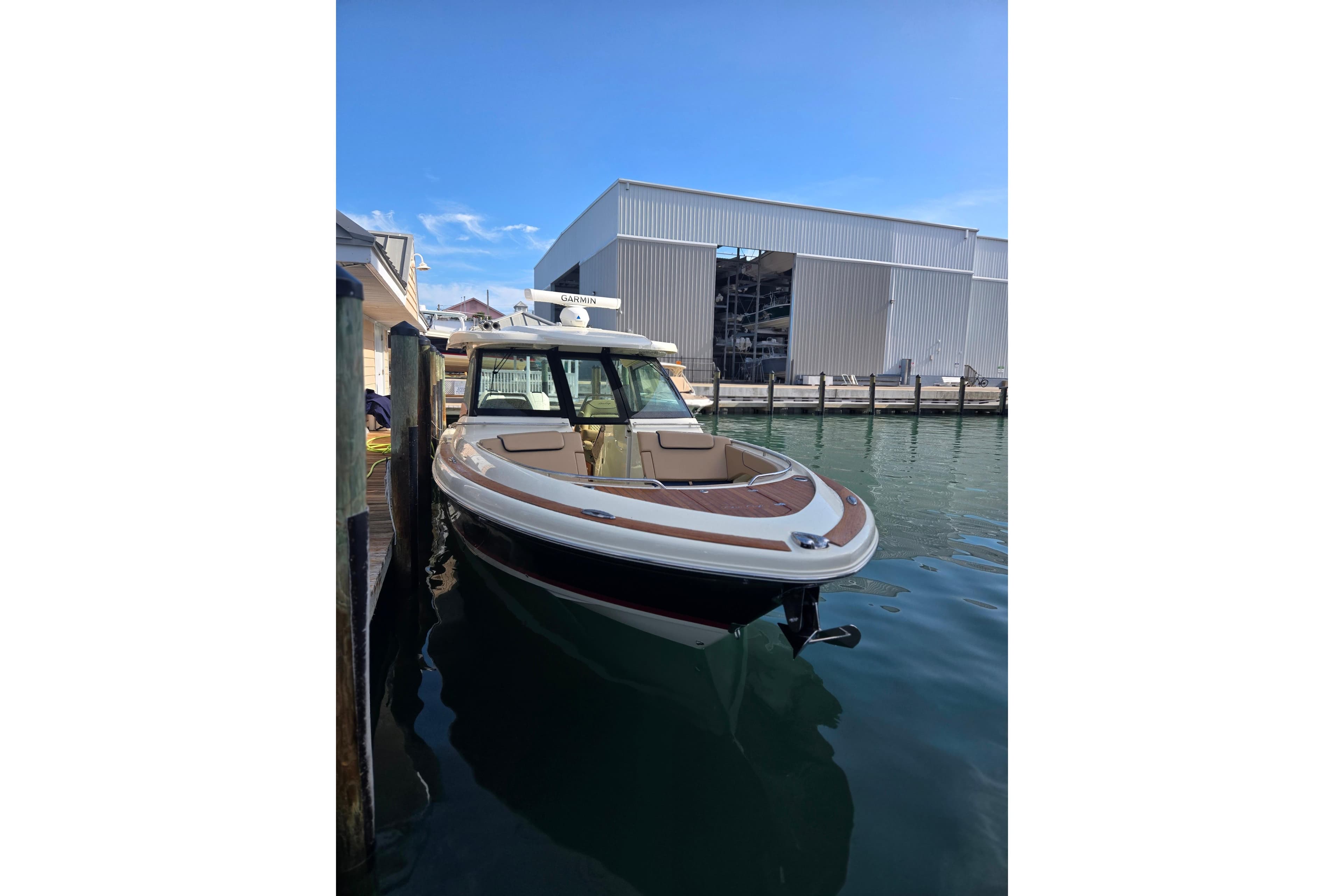 2023 Chris-Craft Calypso 35 boat docked near a marina building.
