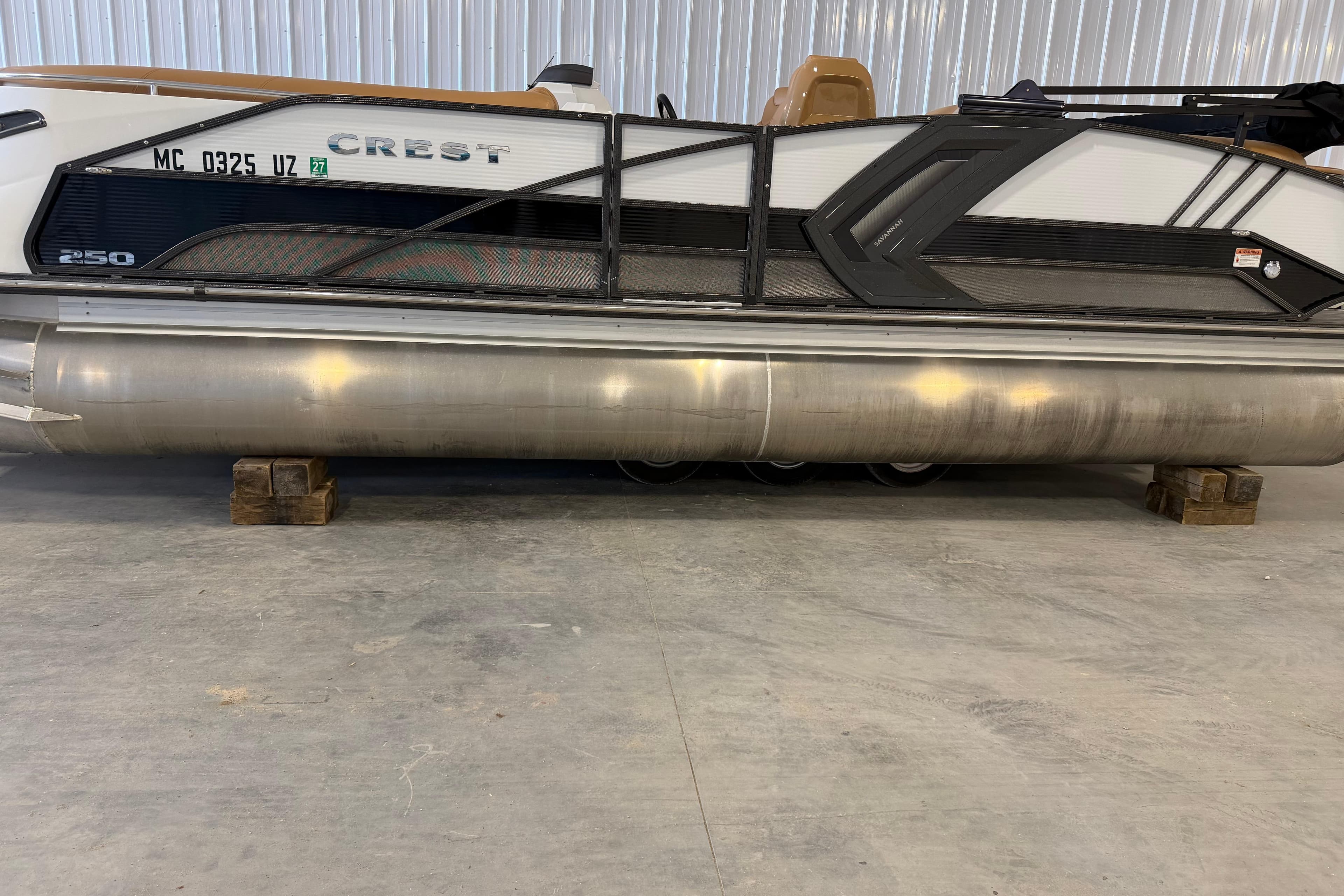 2022 Crest Savannah 250 SLC pontoon boat on wooden blocks in a warehouse.