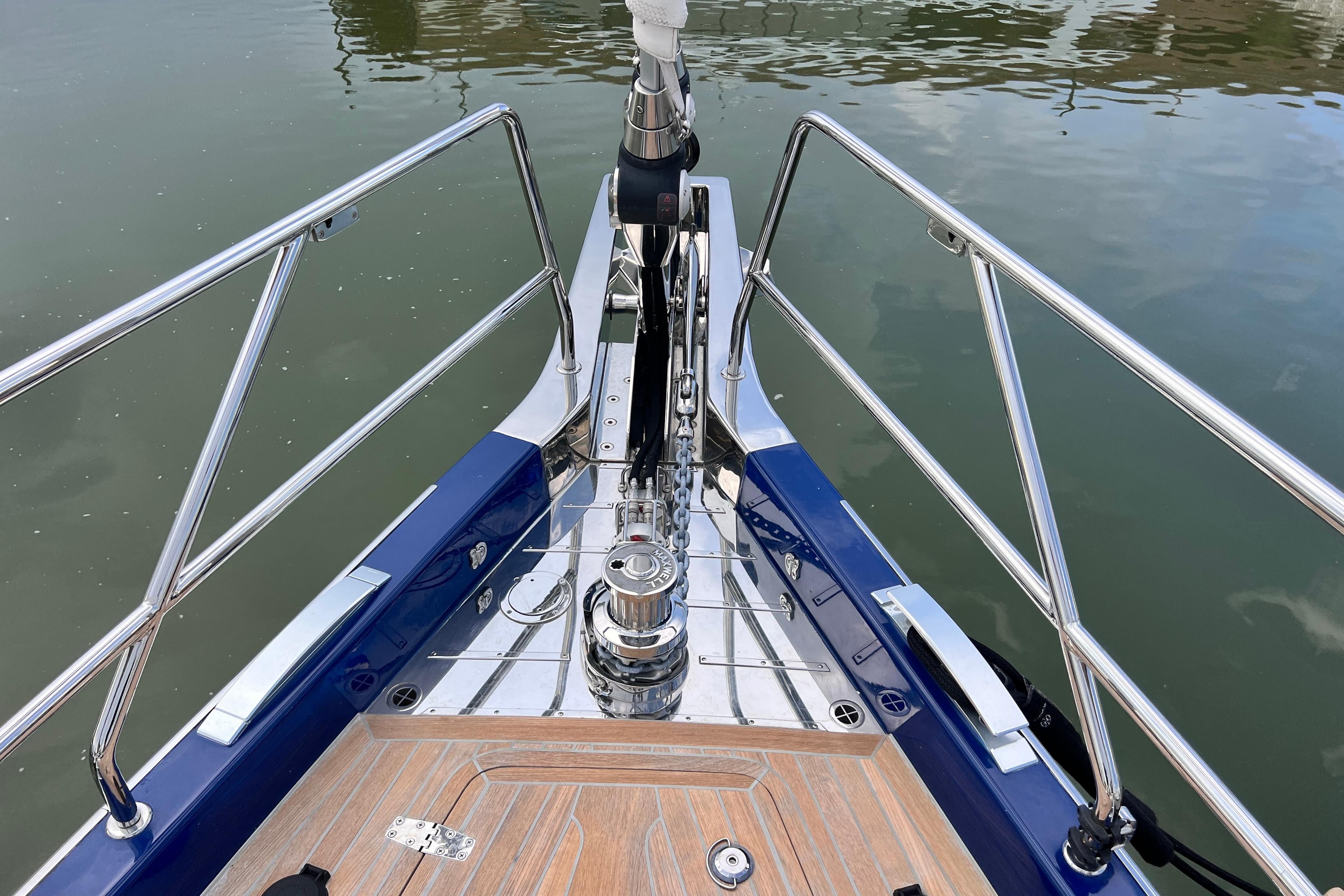 Bow of 2024 Hylas H57 yacht with polished metal fittings and wooden deck.