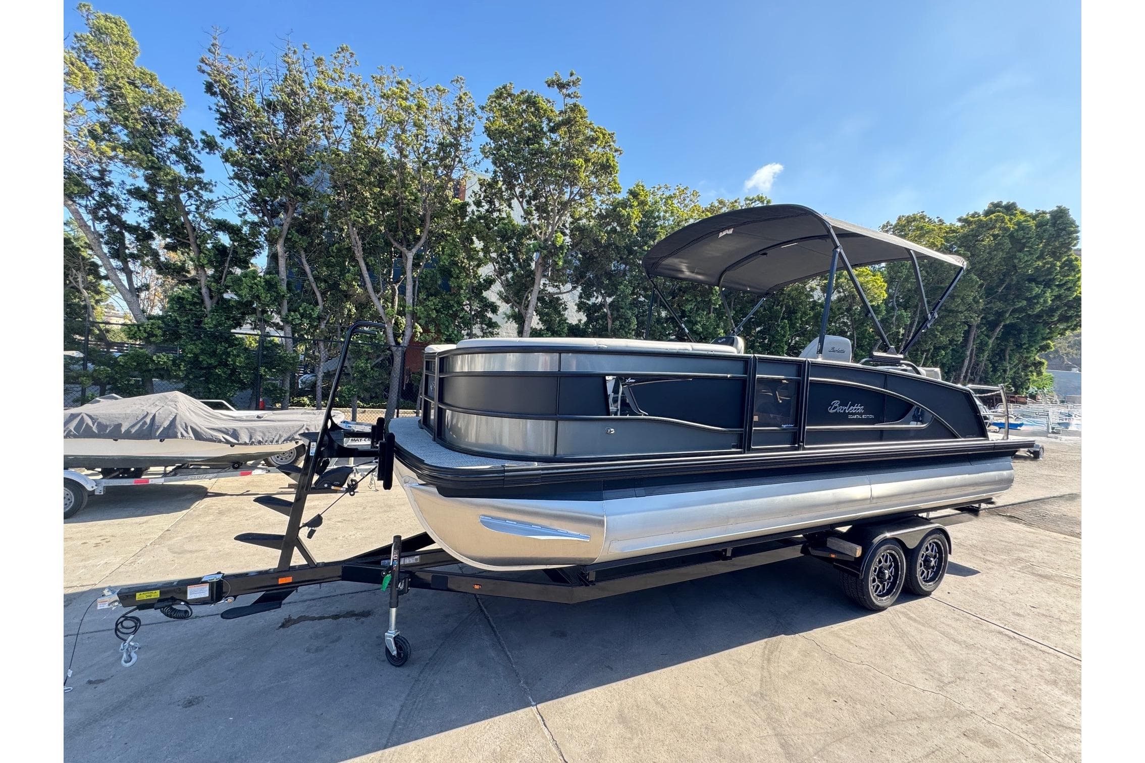 2026 Barletta Lusso 23UC pontoon boat on trailer, parked outdoors.