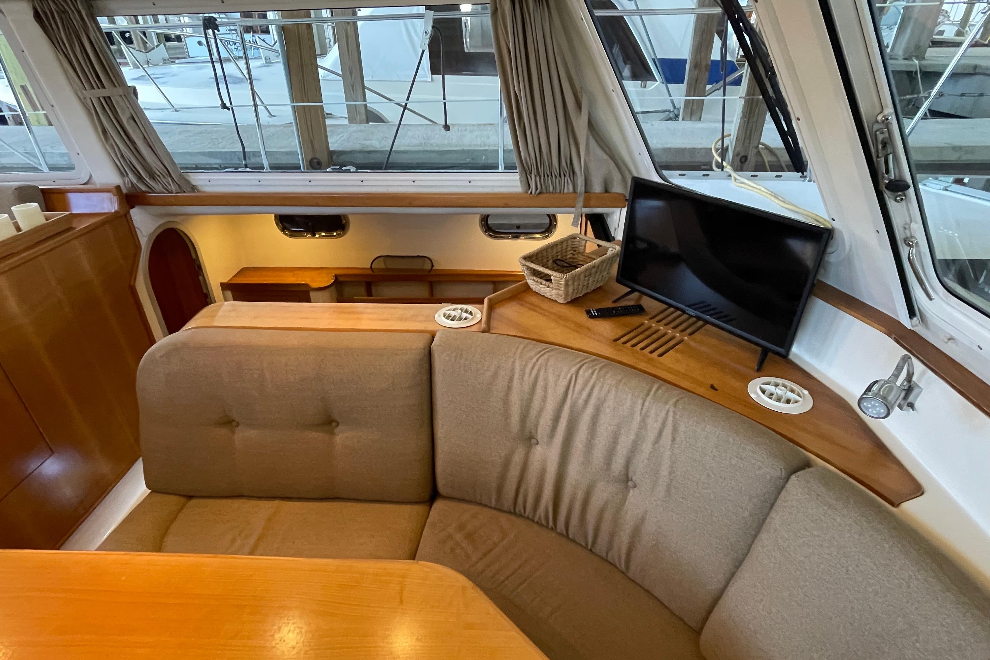 Interior of 2006 PDQ 34 Power Catamaran with cozy seating and TV.