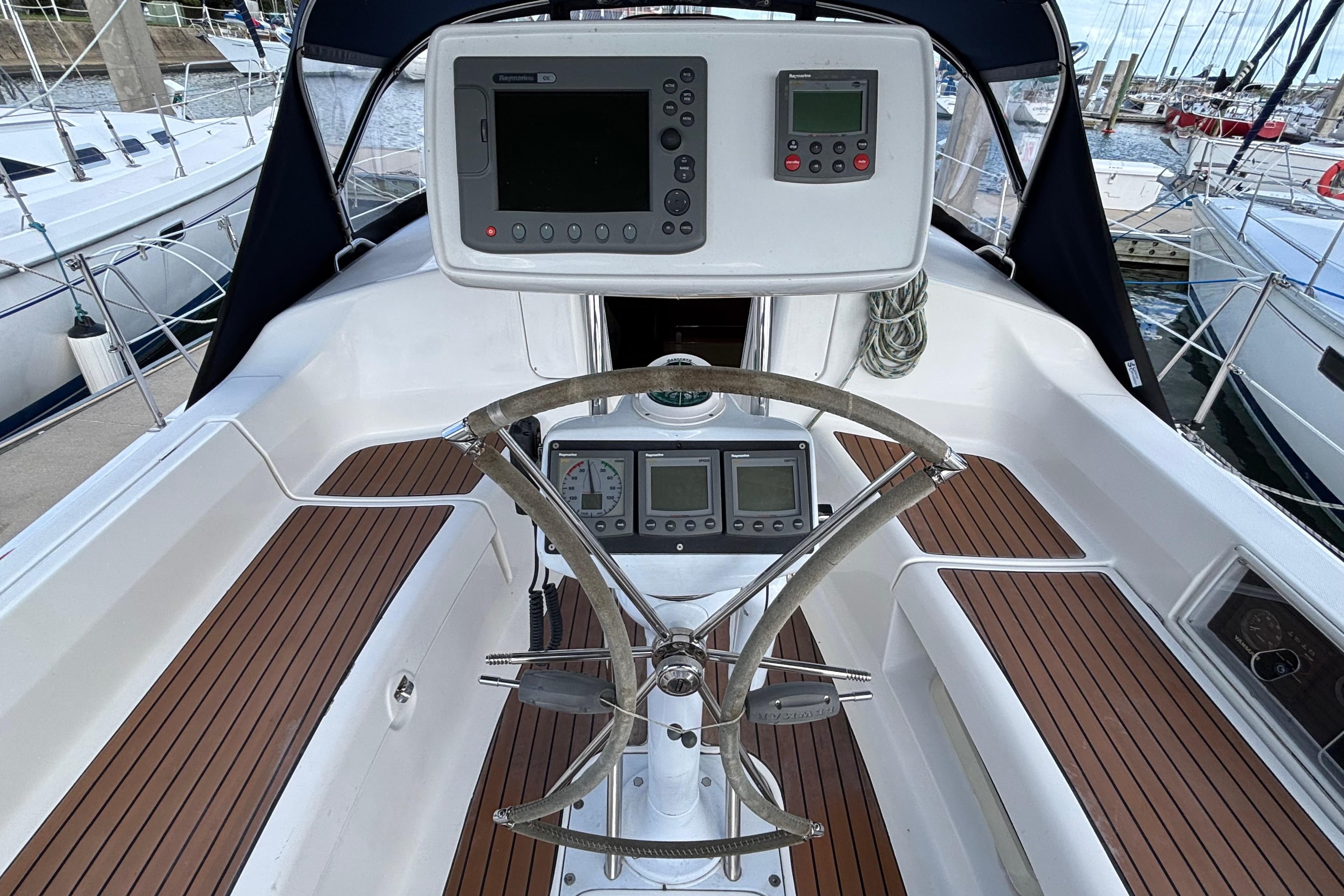 Cockpit of 2006 Hunter 38 sailboat with navigation instruments and wooden deck.