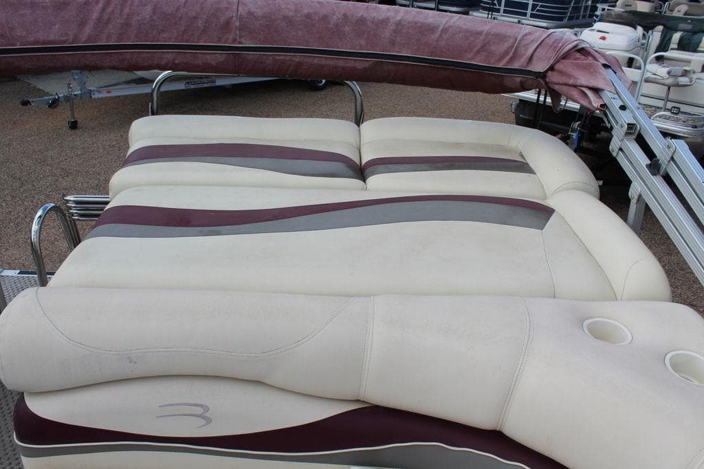2005 Bennington 2275 RL boat seating with beige and maroon upholstery, featuring cup holders.