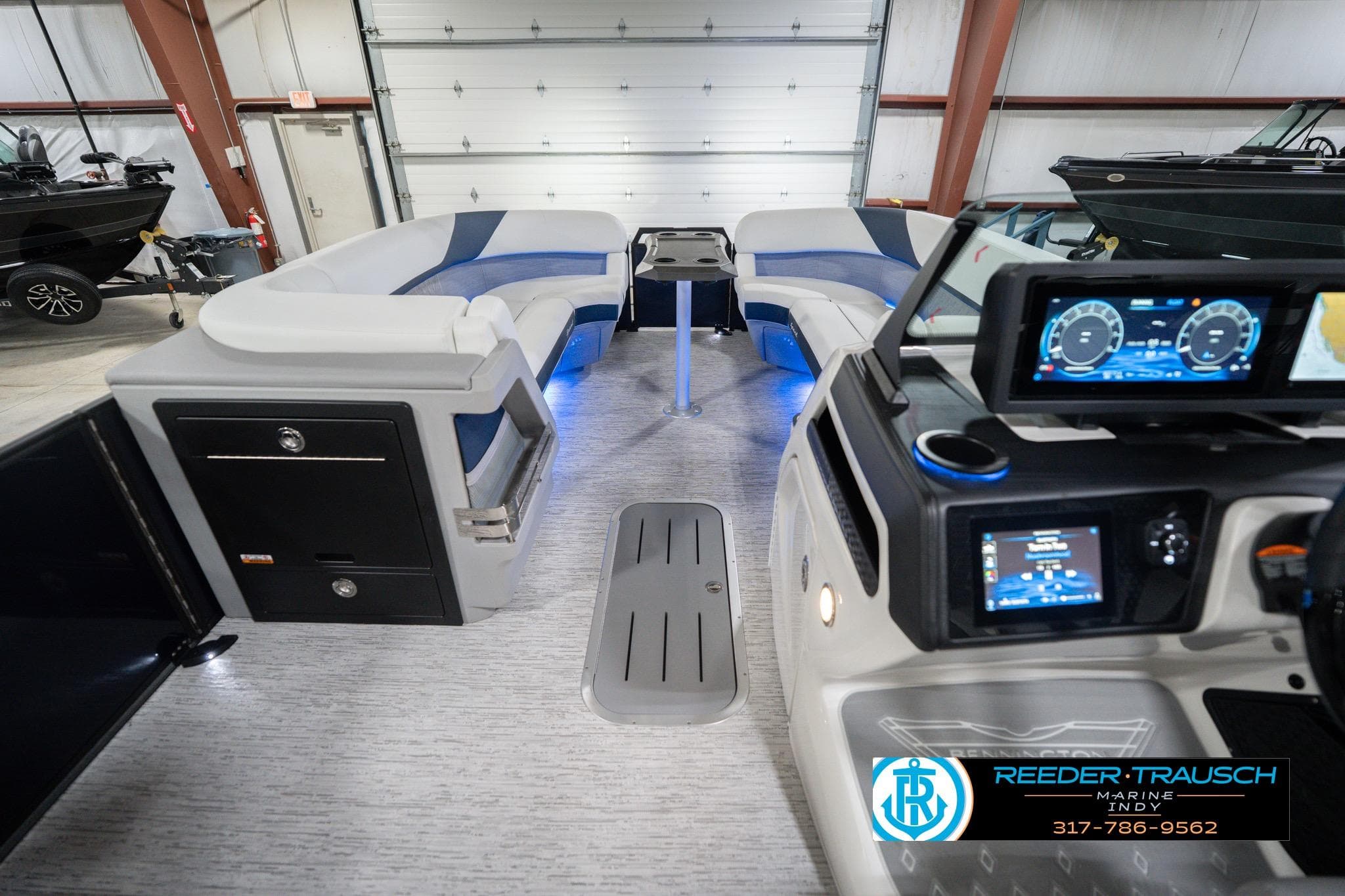 2026 Bennington 24 MCSB boat interior with modern dashboard and seating in a showroom.