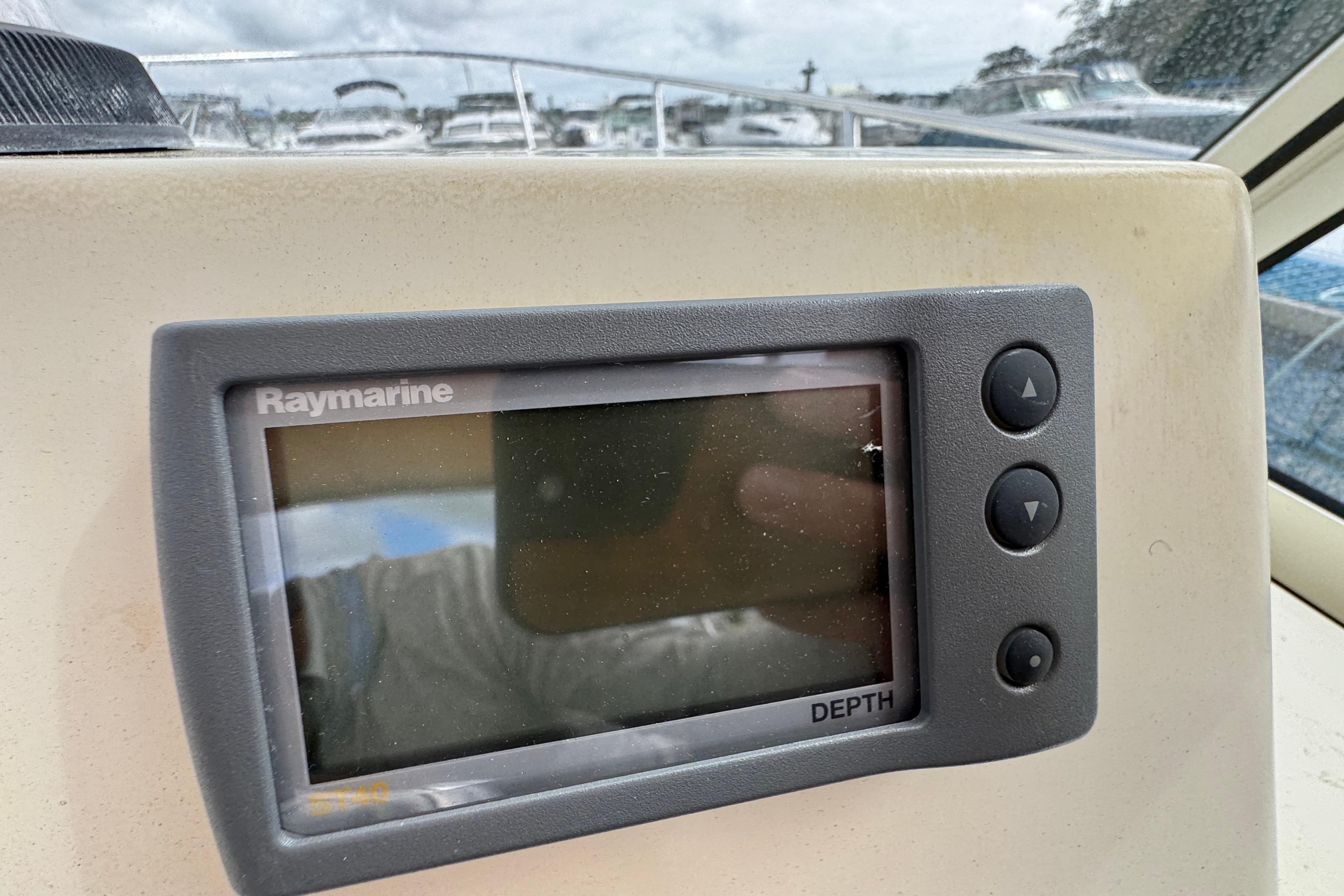 Raymarine depth display on 2006 Limestone 26 boat dashboard, with marina background.