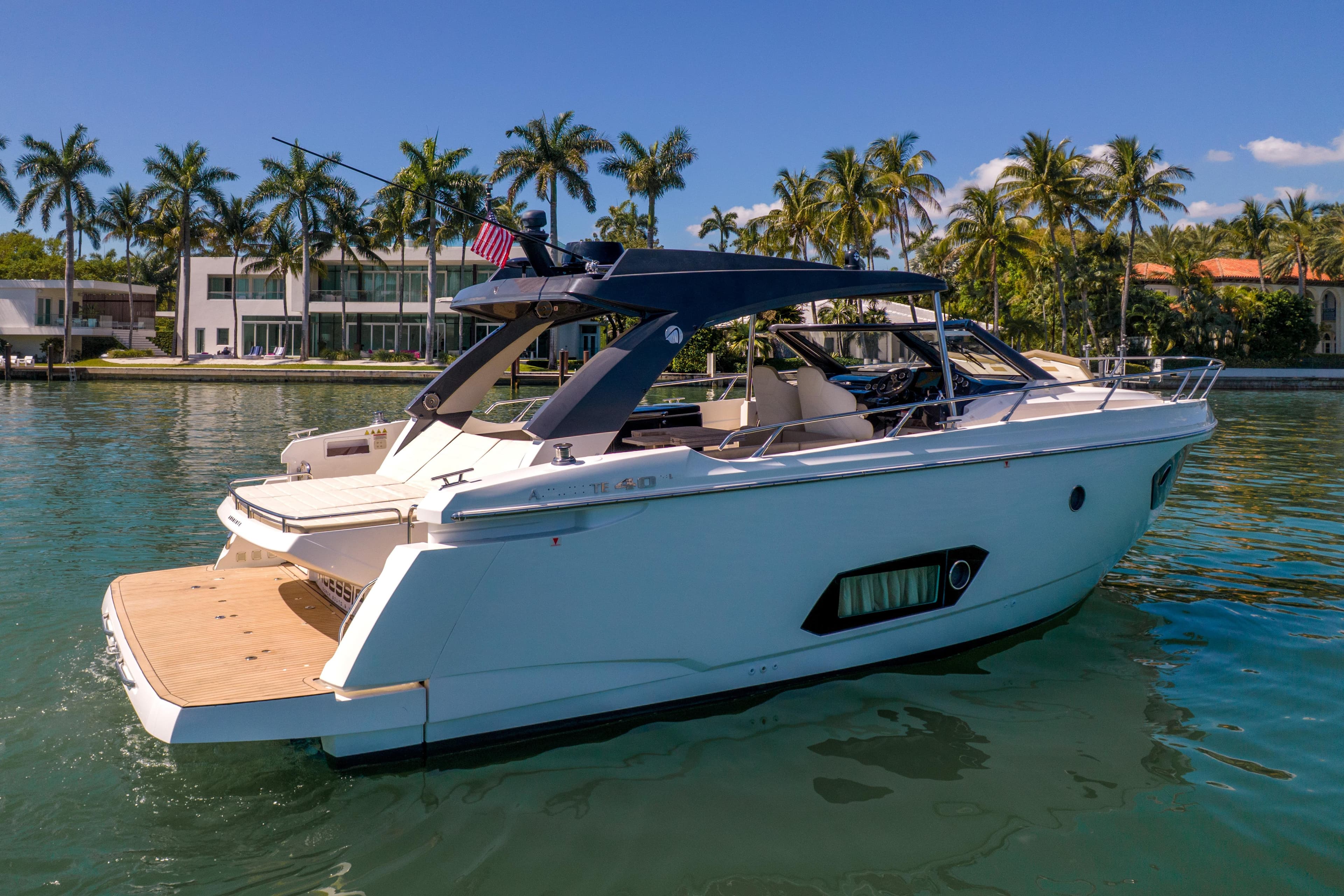 Luxury 2017 Absolute 40 STL yacht docked near palm trees and waterfront homes.