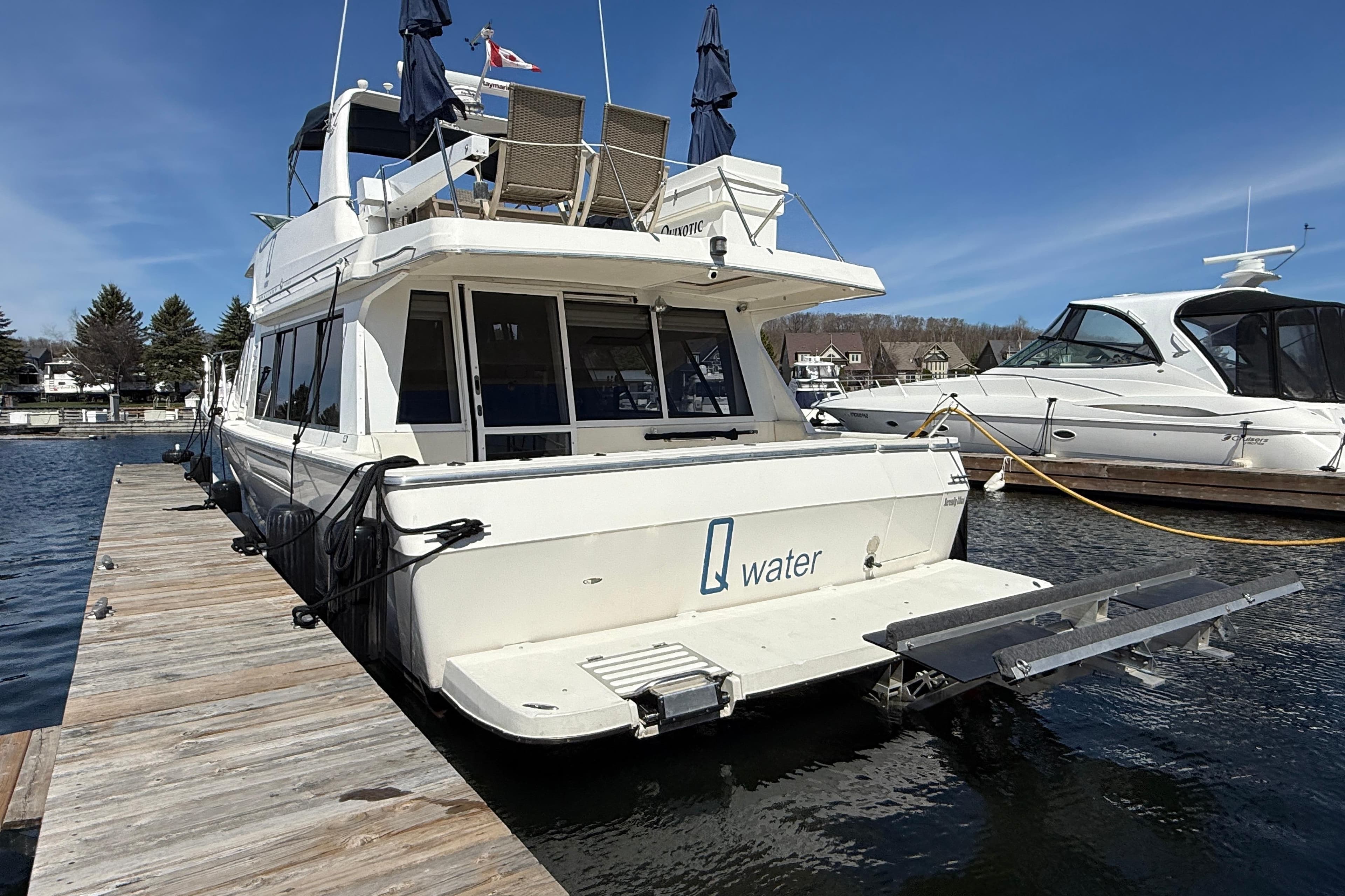 1997 Bayliner 4788 Pilot House Motoryacht docked at marina under clear blue sky.