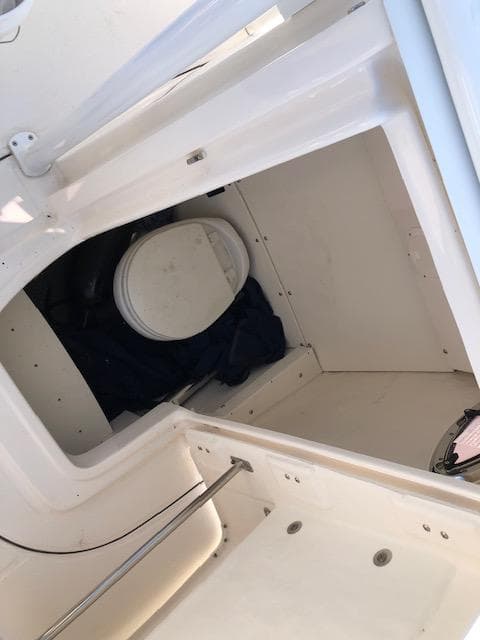 2022 Robalo R242 Center Console boat interior with compact marine toilet.