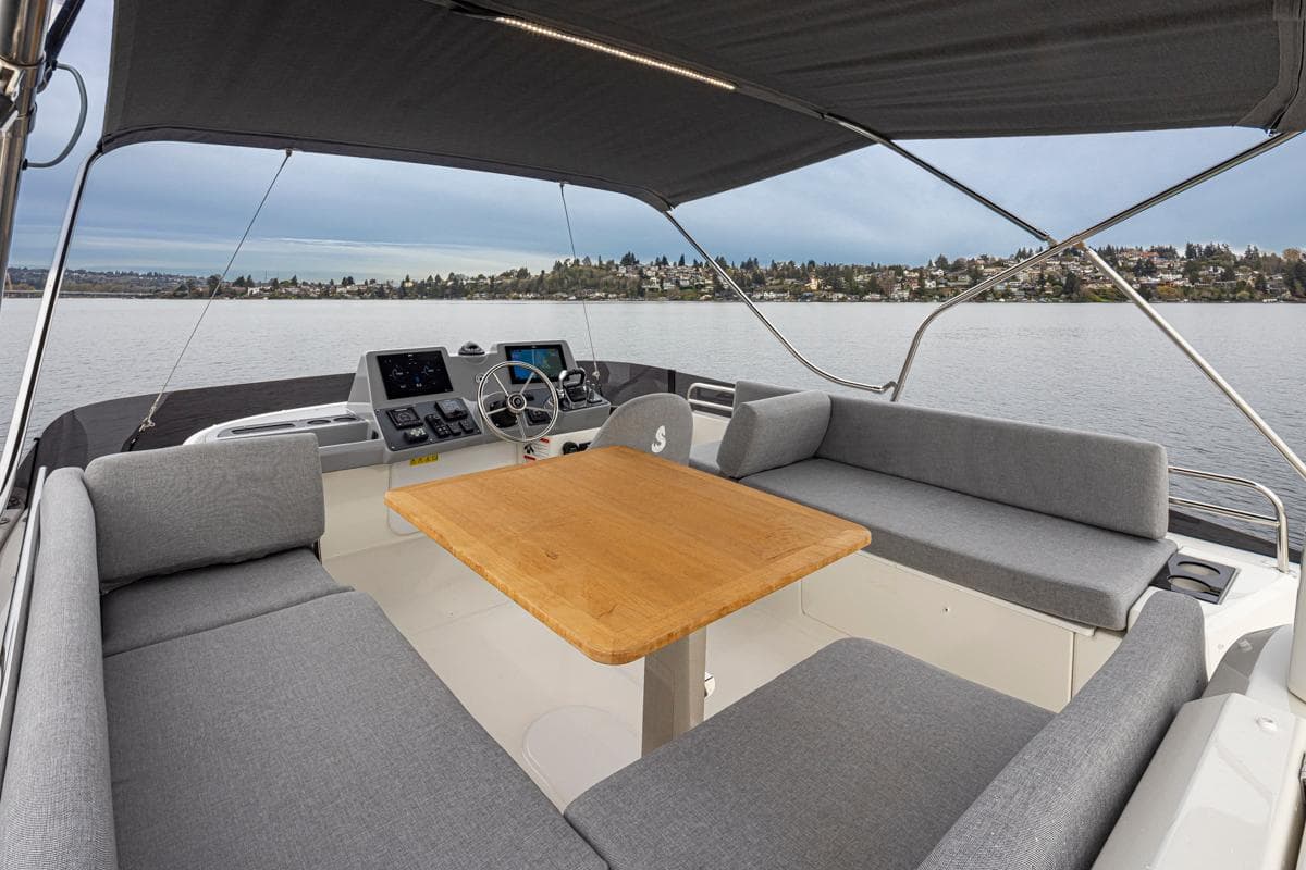 2026 Beneteau Swift Trawler 41 Fly, spacious flybridge with seating and helm, overlooking serene waters.