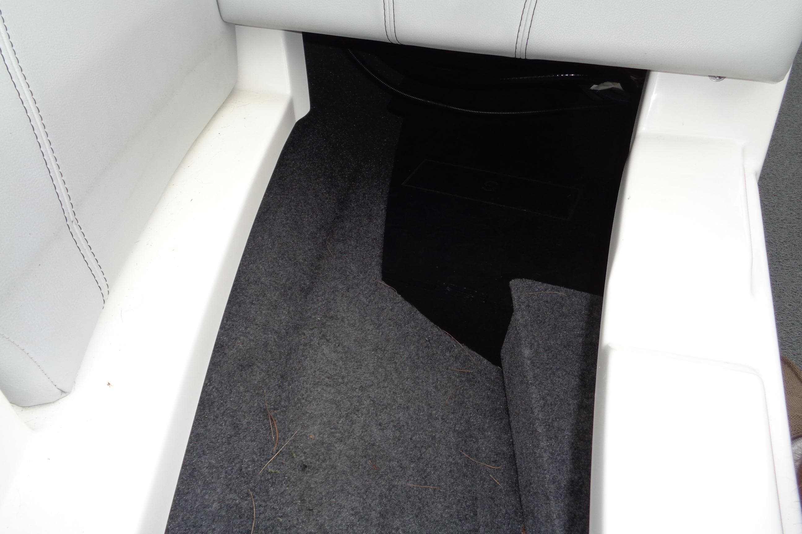 Interior view of a 2020 MasterCraft XT23 boat, featuring carpeted flooring and white seating.