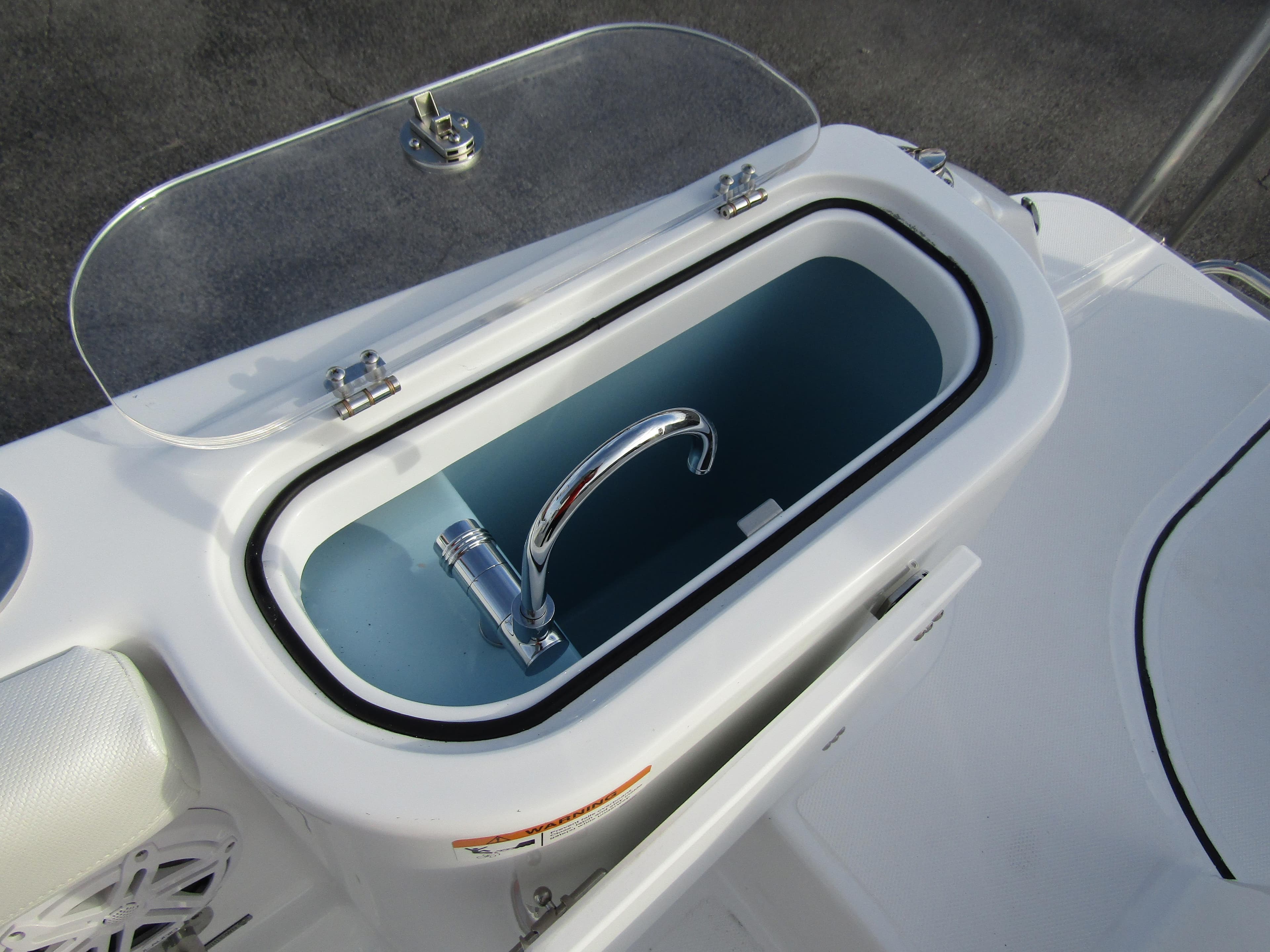 Livewell on 2025 Wellcraft 243 Fisherman boat, featuring a sleek design and functional faucet.