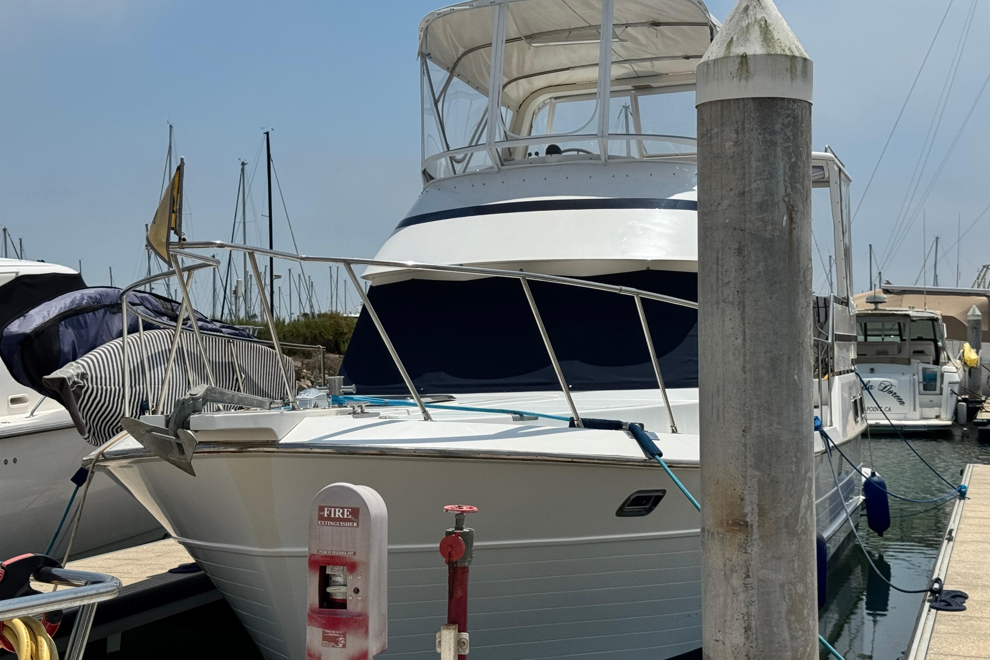1999 Heritage East Sundeck 36 yacht docked at marina, featuring a covered upper deck.