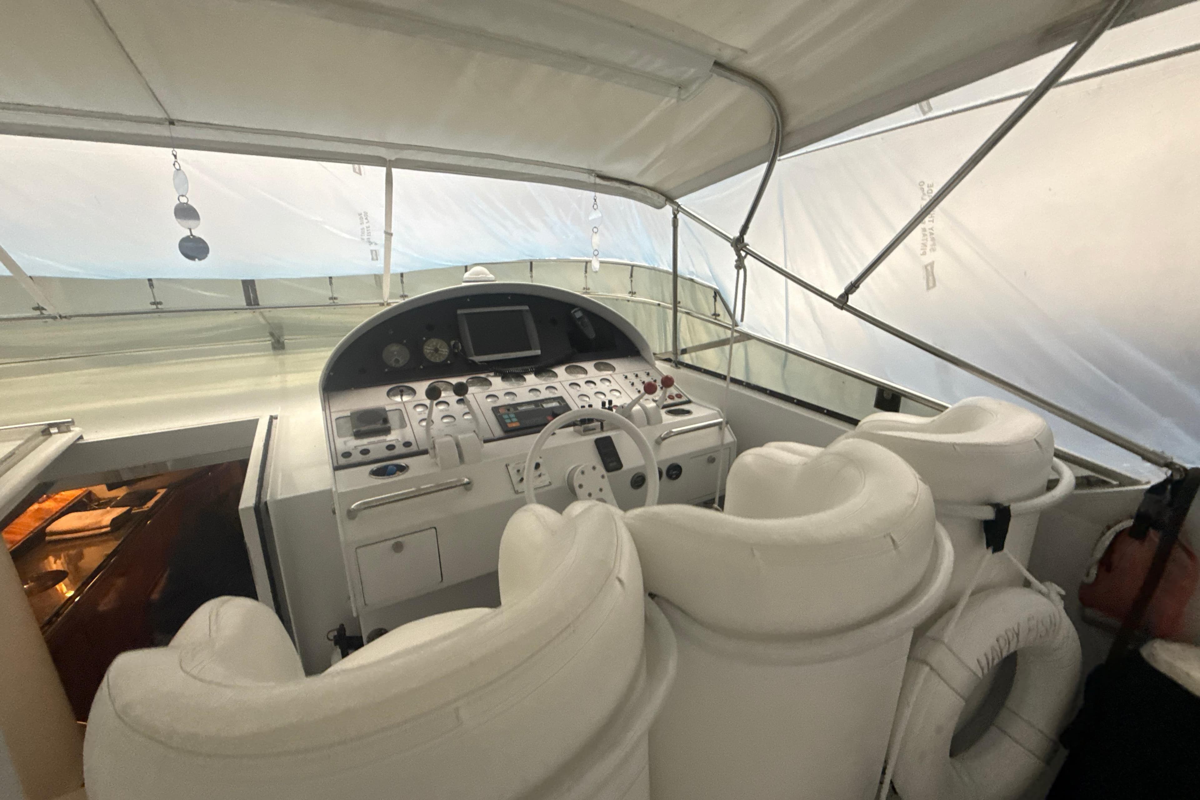 Cockpit of a 1999 Diaship 53 yacht with white seating and navigation controls.