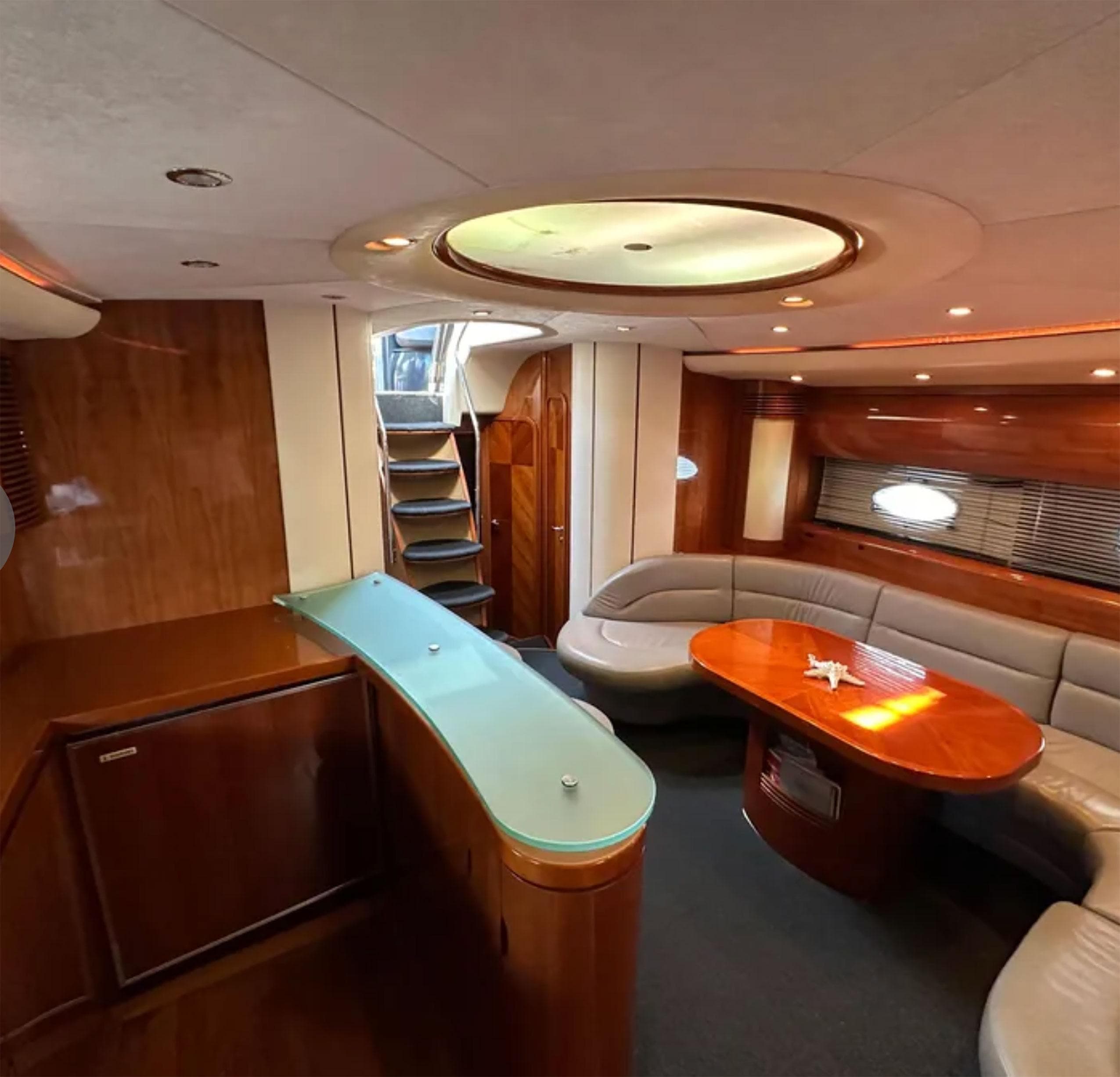 Luxurious interior of 2003 Princess V65 yacht with elegant wood finishes and modern seating.