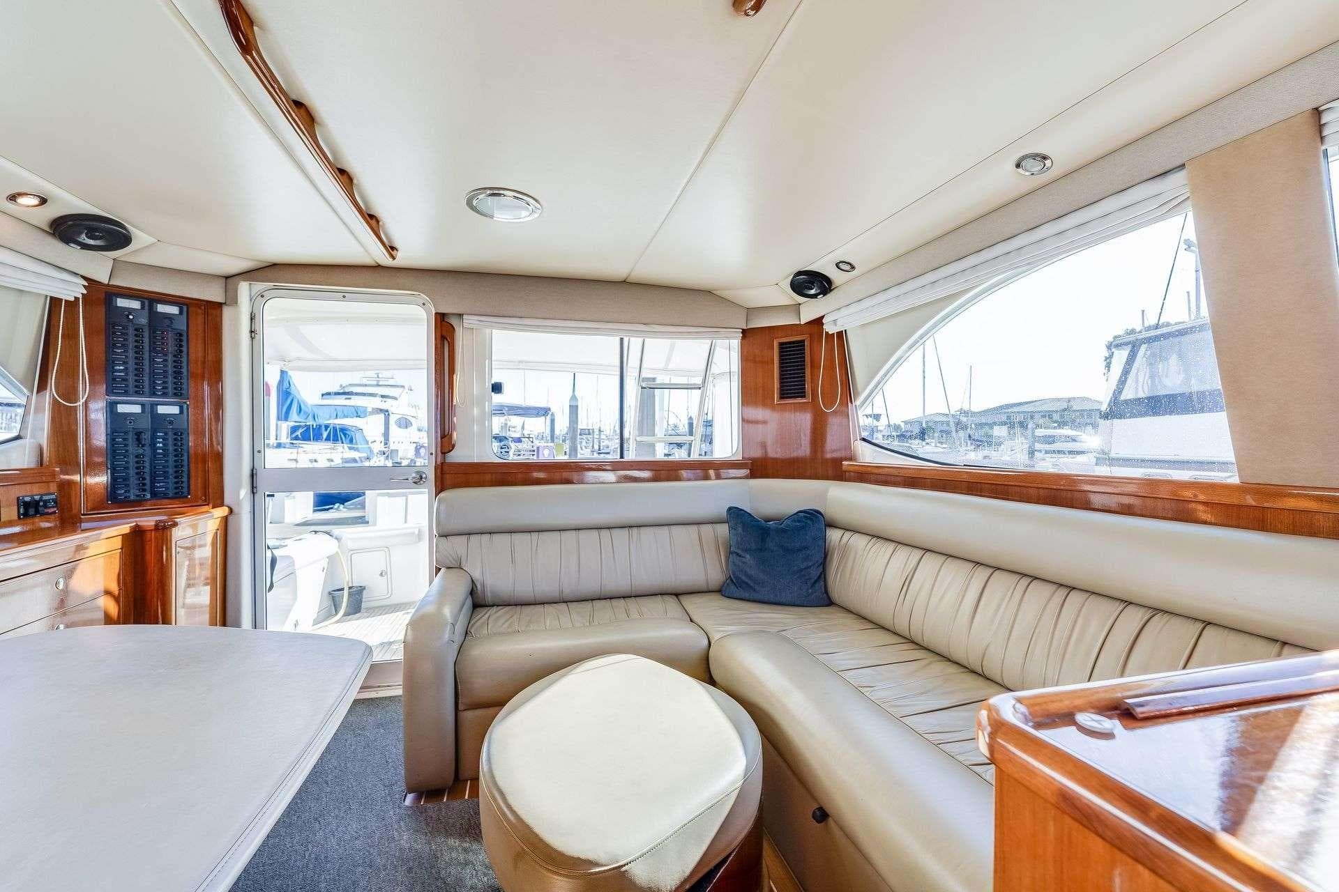 Luxurious interior of a 2004 Riviera Convertible yacht with leather seating and panoramic windows.