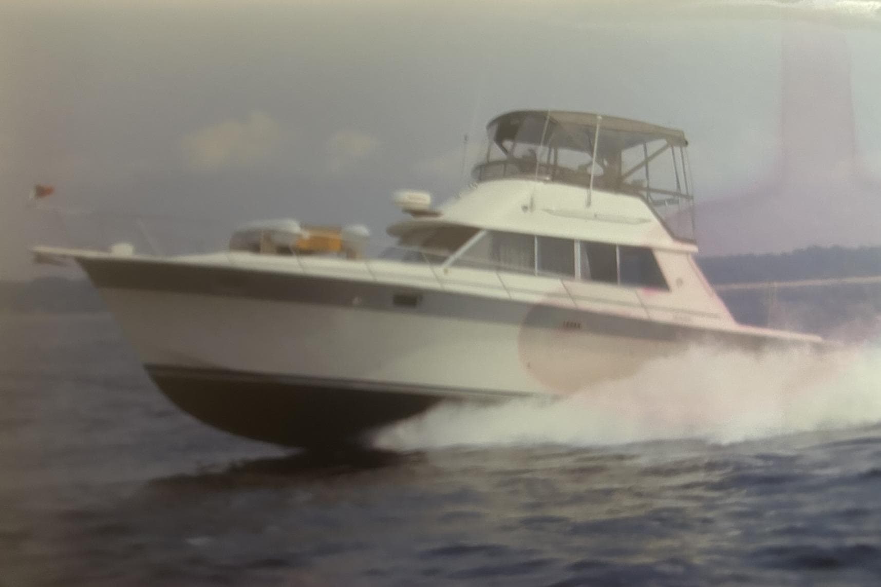 1988 Silverton 37 Convertible yacht cruising on open water.