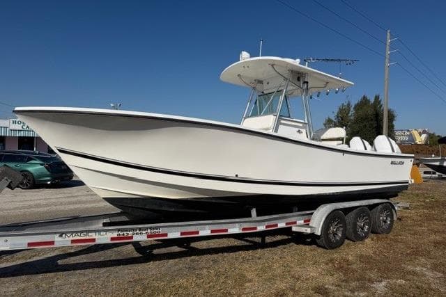 2002 Regulator 26 Forward Seating boat on trailer, side view, outdoors.