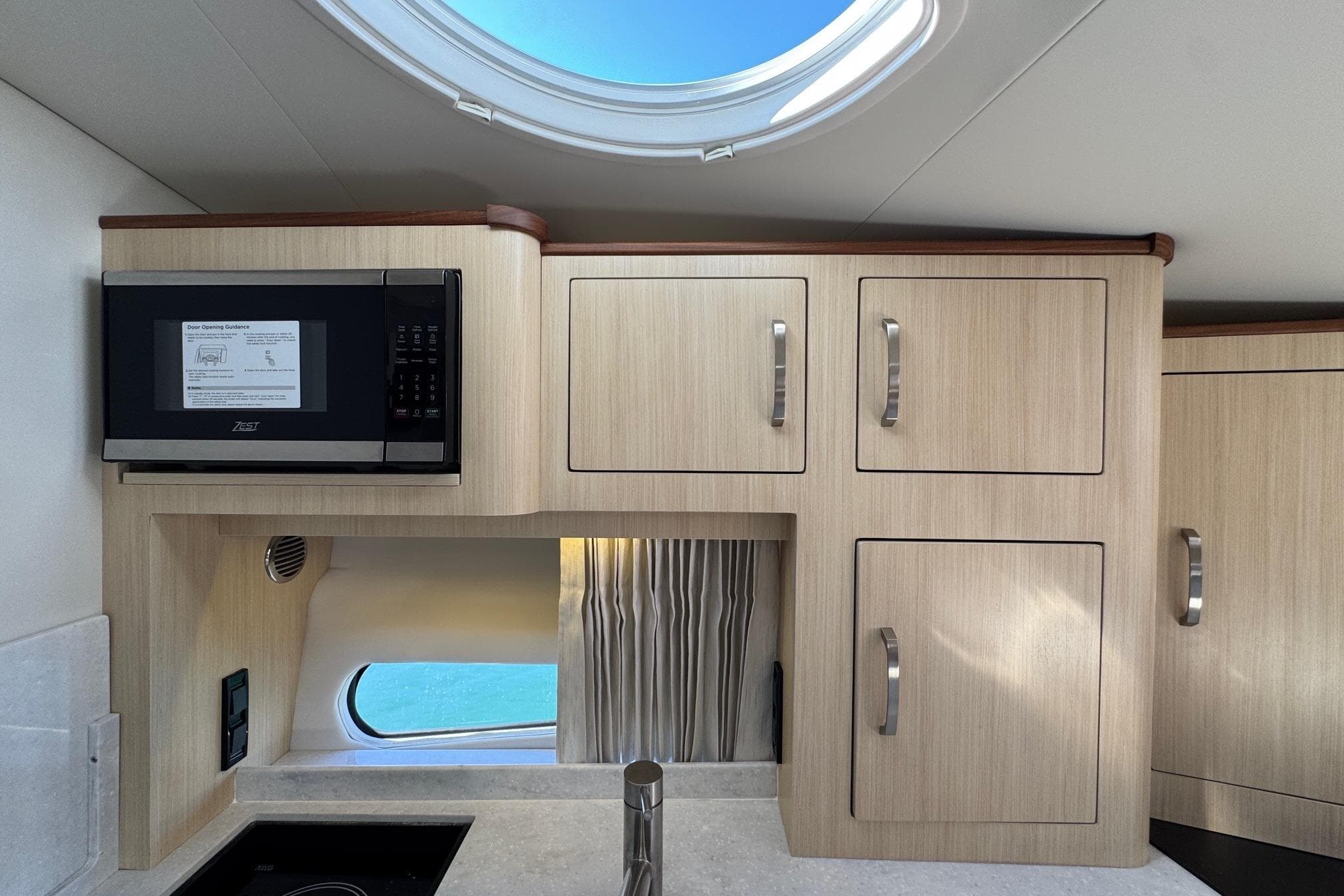 Modern kitchen interior of 2026 Regal 33 XO boat with microwave and cabinets.