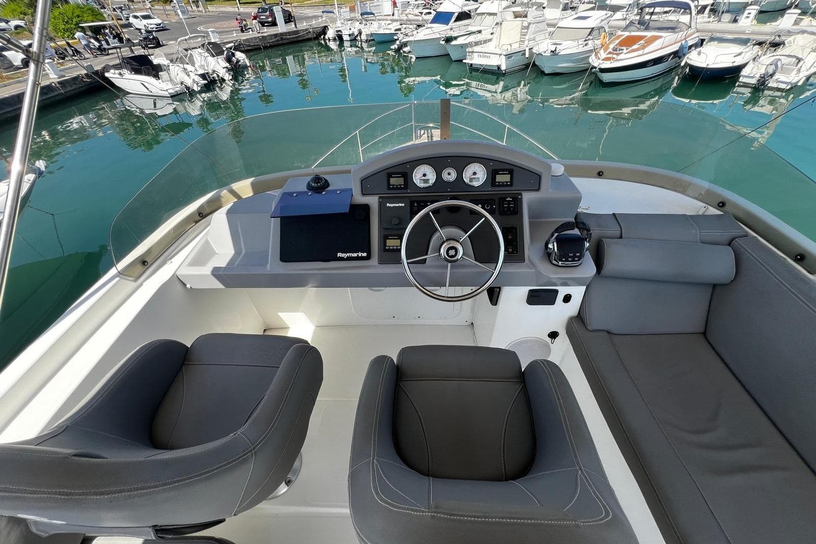 2017 Beneteau Swift Trawler 44 helm with modern controls, docked in a marina.