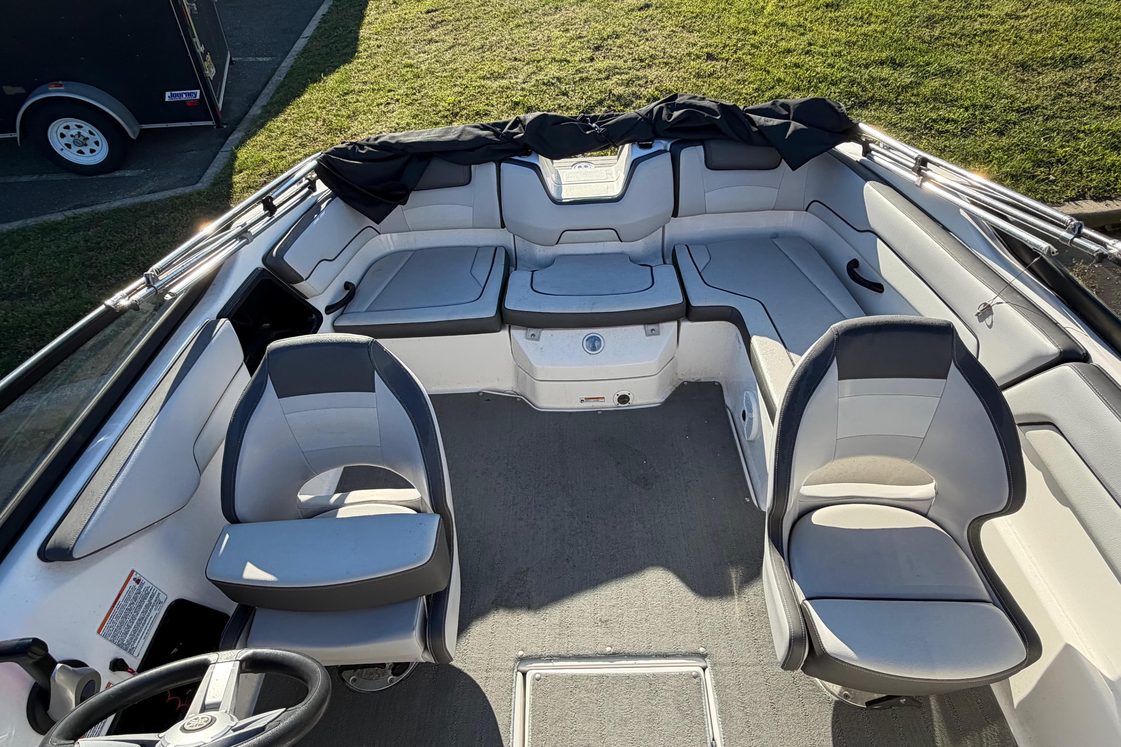 2019 Yamaha Boats SX190 interior with seating and steering wheel, parked on grass.