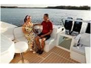Couple relaxing on 2024 Formula 500 Super Sport Crossover boat, enjoying a scenic lake view.