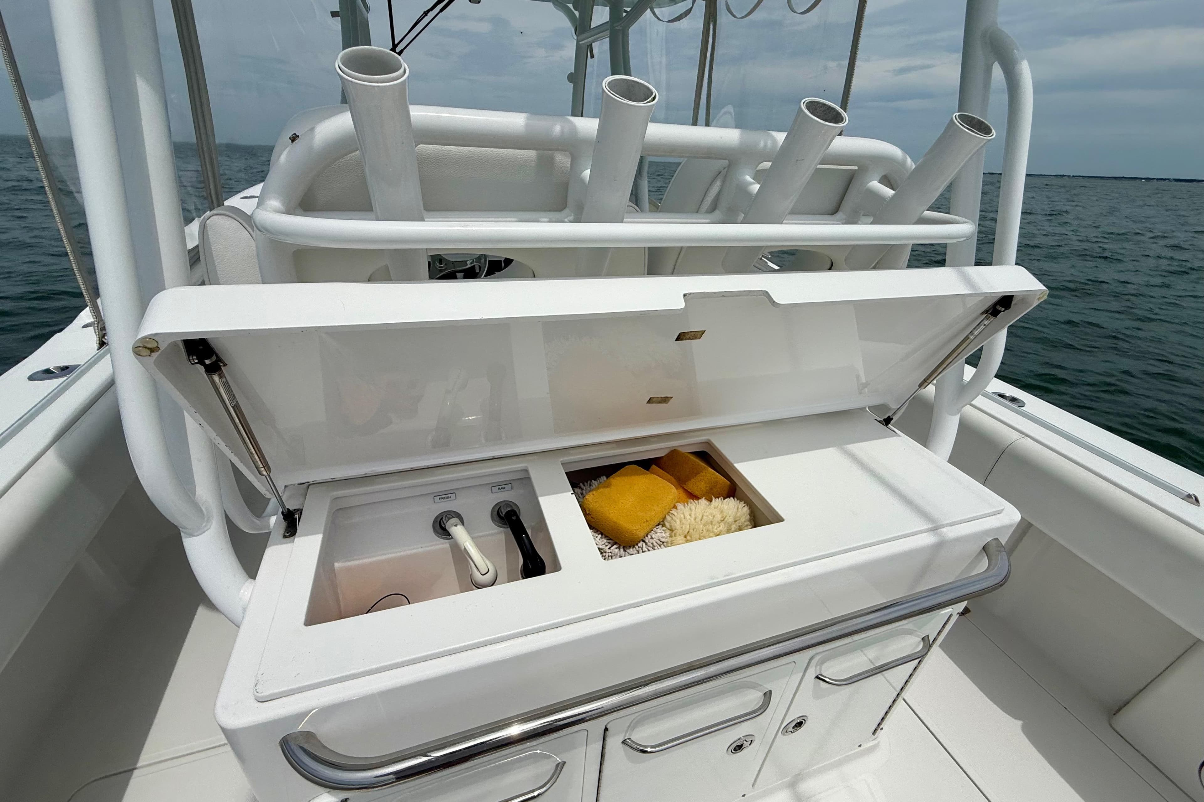 Open storage compartment on 2017 Southport 33 FE boat with cleaning supplies.