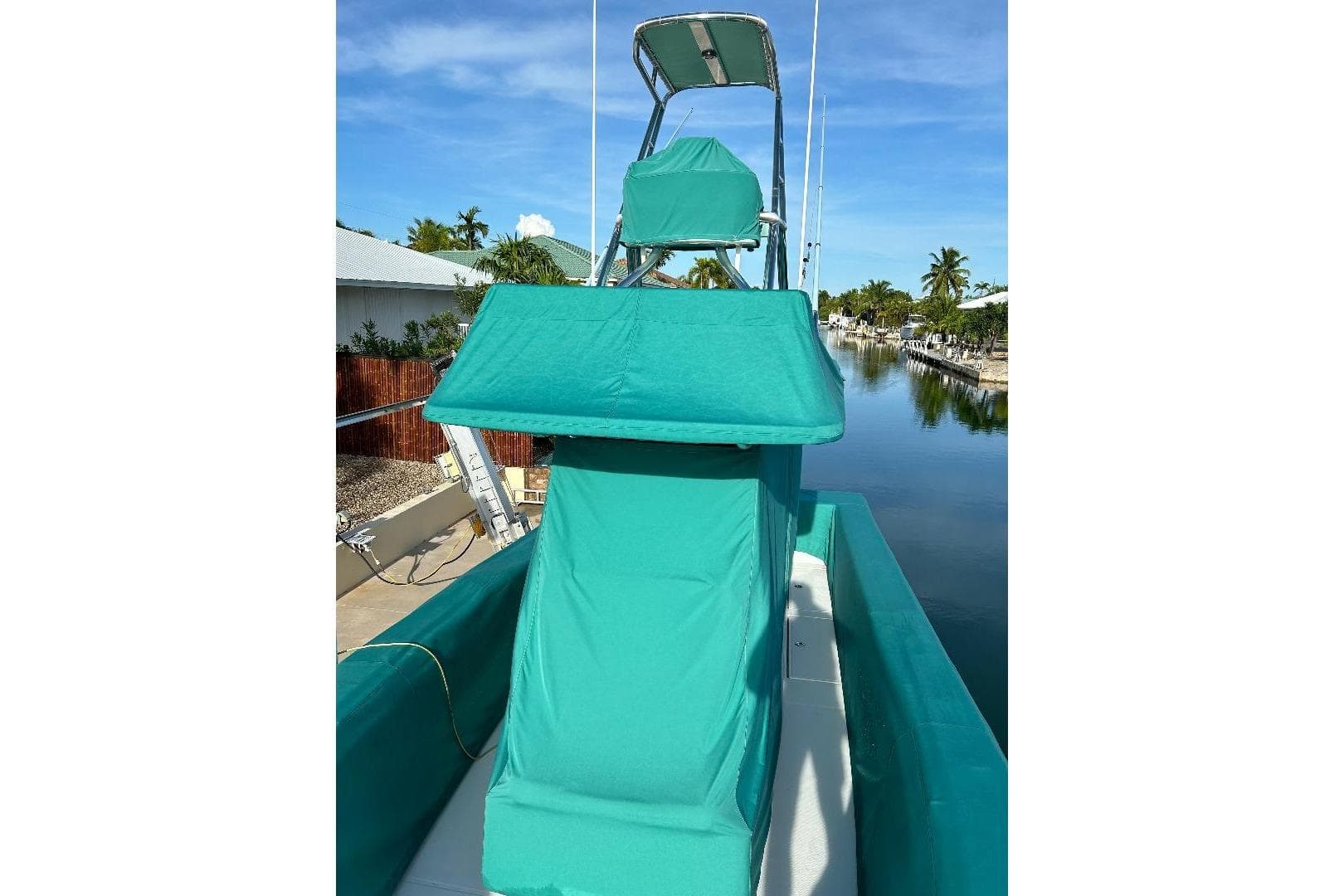 2023 SeaHunter 31 Tournament boat with teal covers, docked by a canal.