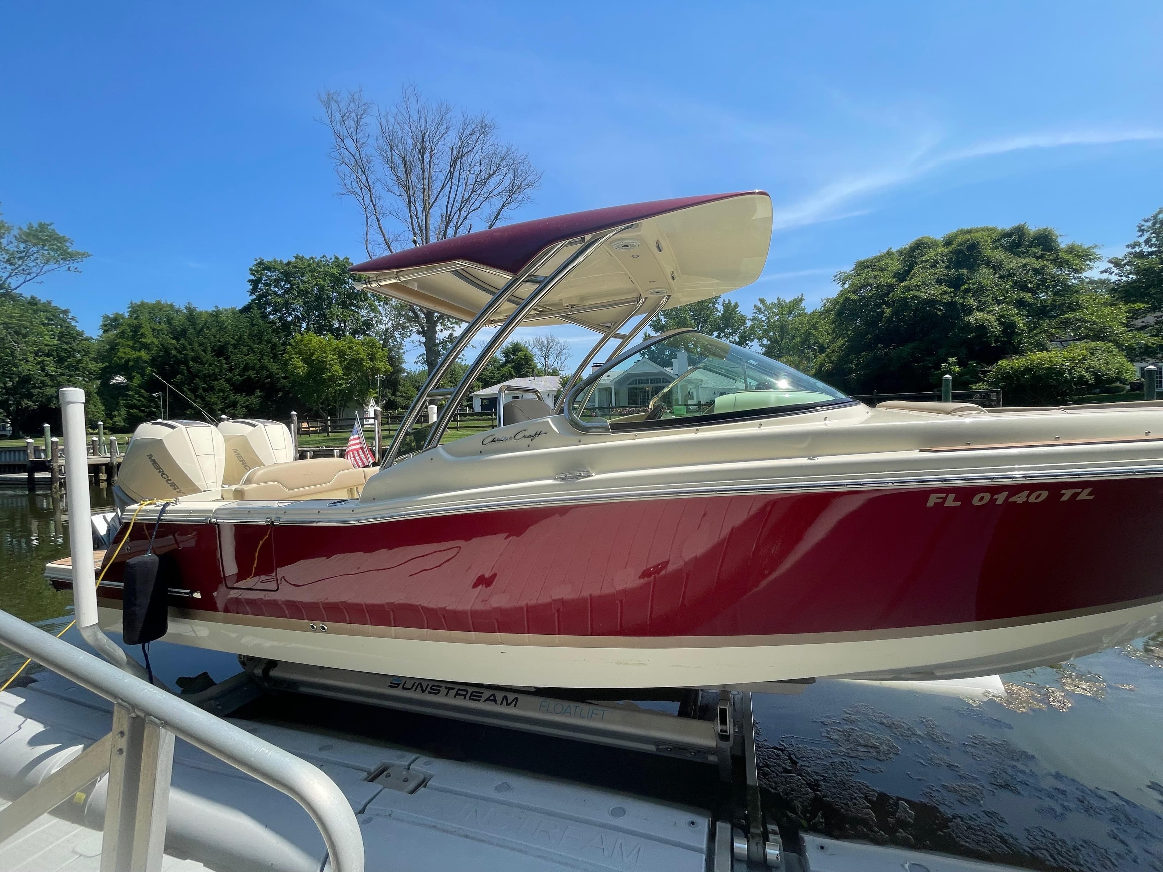 2023 Chris-Craft Calypso 28 boat docked, featuring a sleek red and white design.