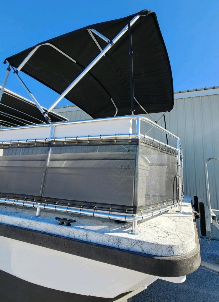 2025 A&M Manufacturing Salty 23 boat with canopy, docked under clear blue sky.