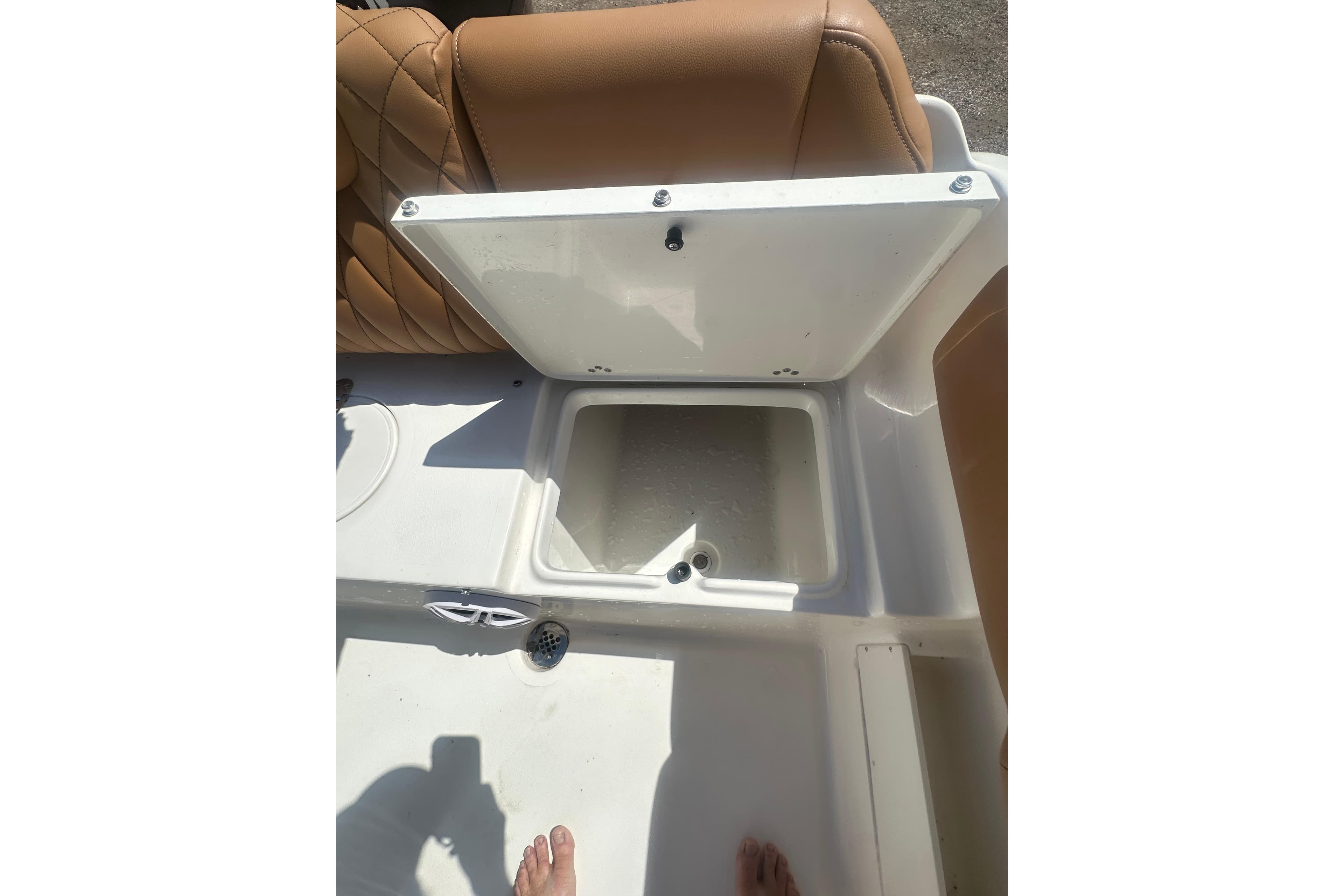 Open storage compartment on 2026 Key West 239 FS boat with tan seating.
