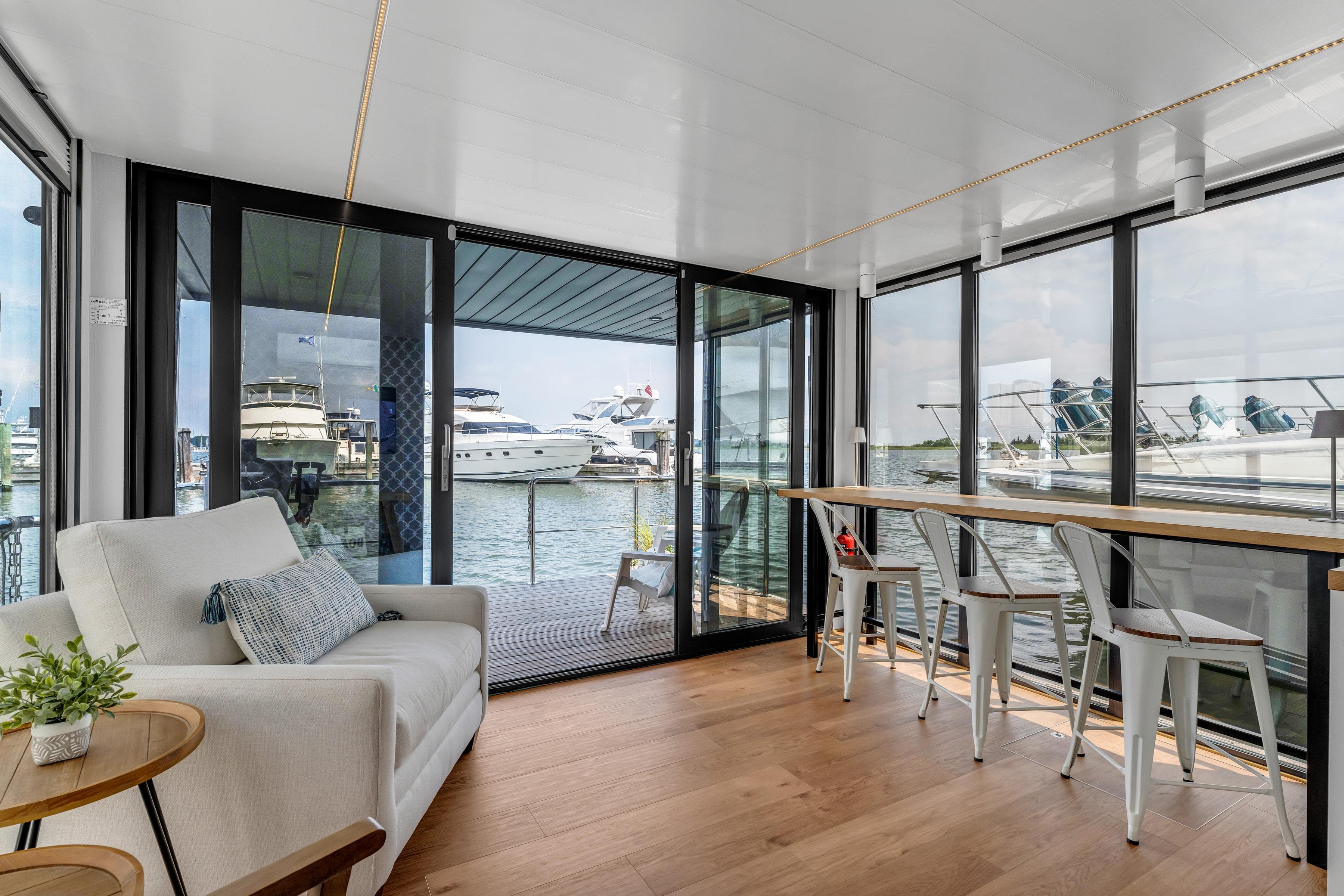 Modern Waterlodge Apart L Long 2026 interior with waterfront view, featuring cozy seating and dining area.