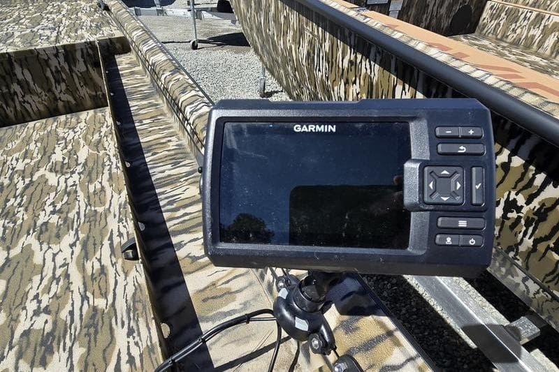 Garmin device mounted on 2025 Avid 16 Commander boat with camouflage pattern.